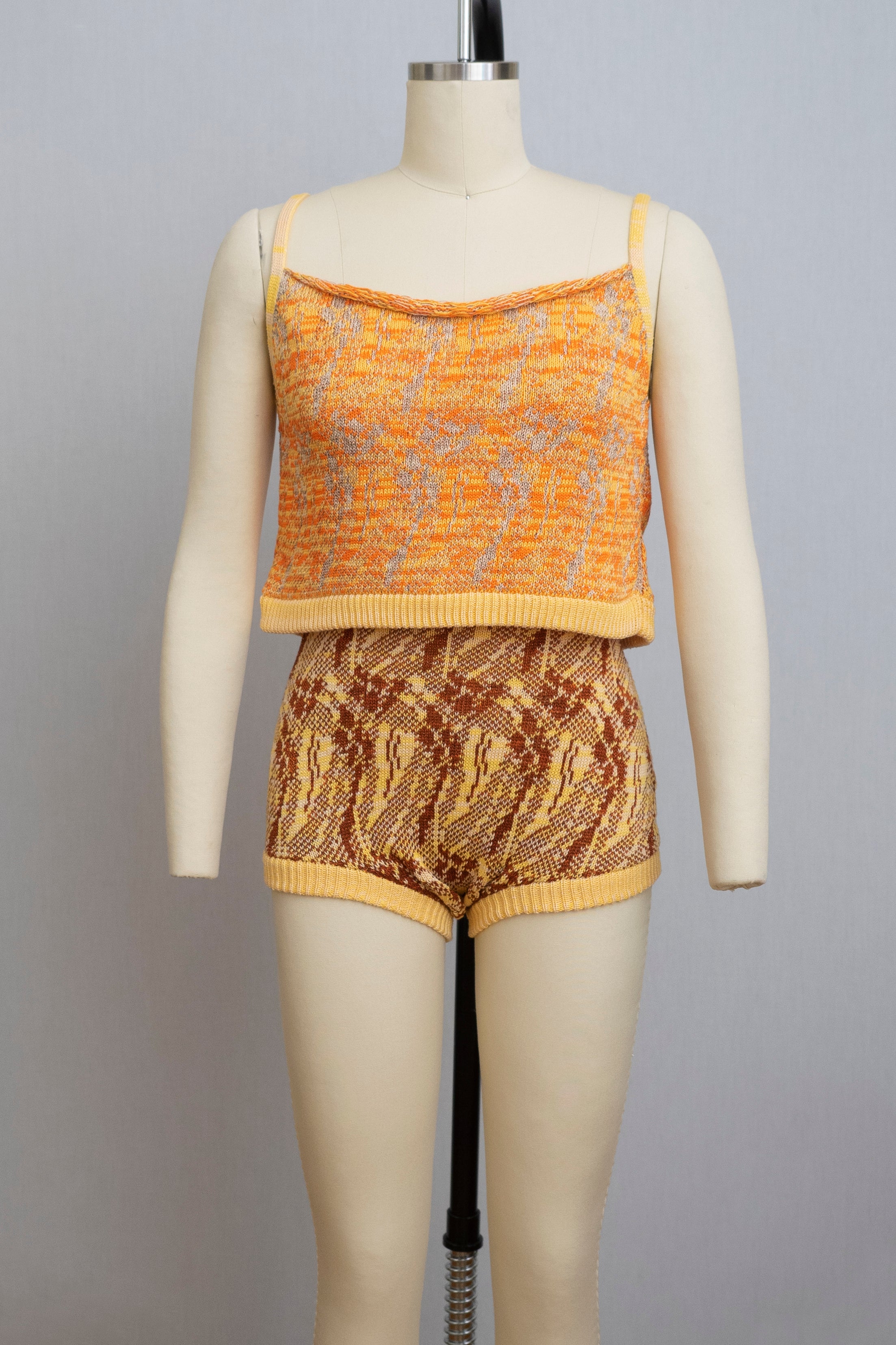 dress form wearing a knit playsuit in oranges and yellows