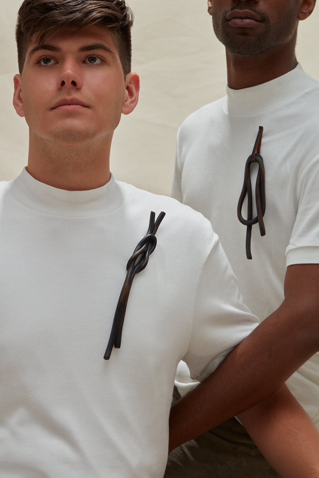 Two models wearing dark wooden knot brooches 