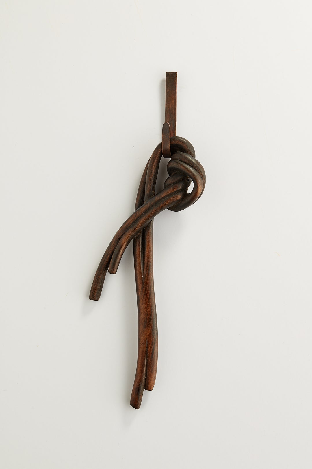 A dark knot brooch carved from wood