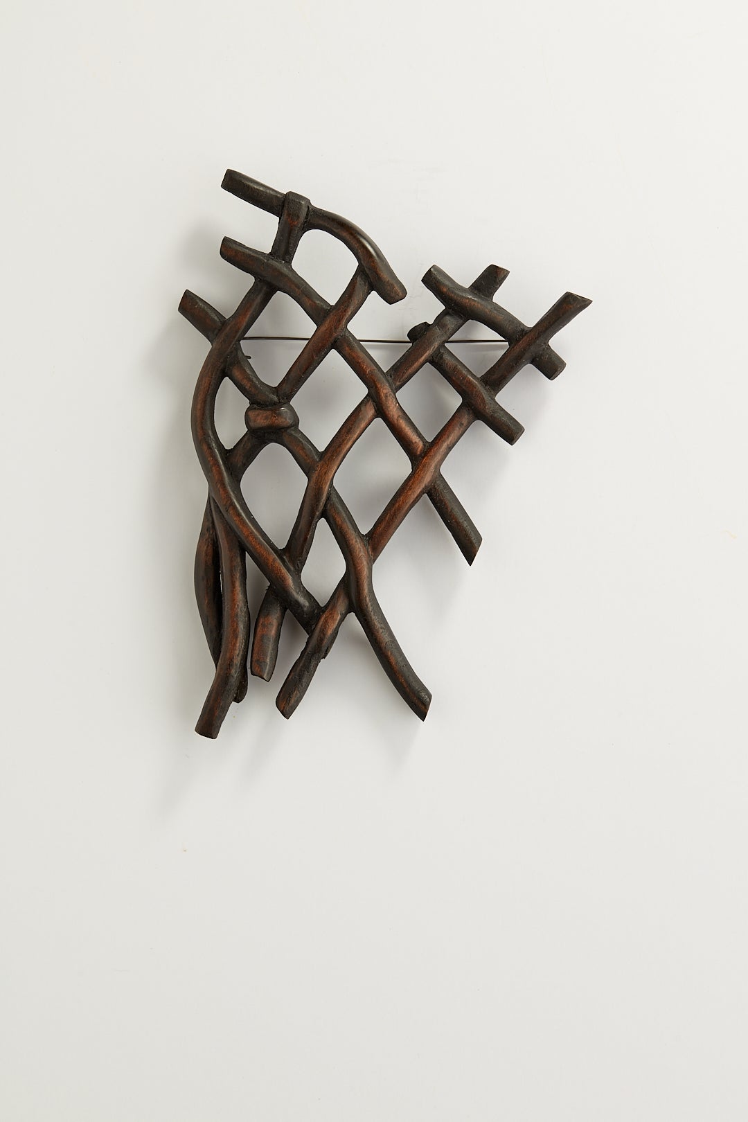 A dark knot brooch carved from wood