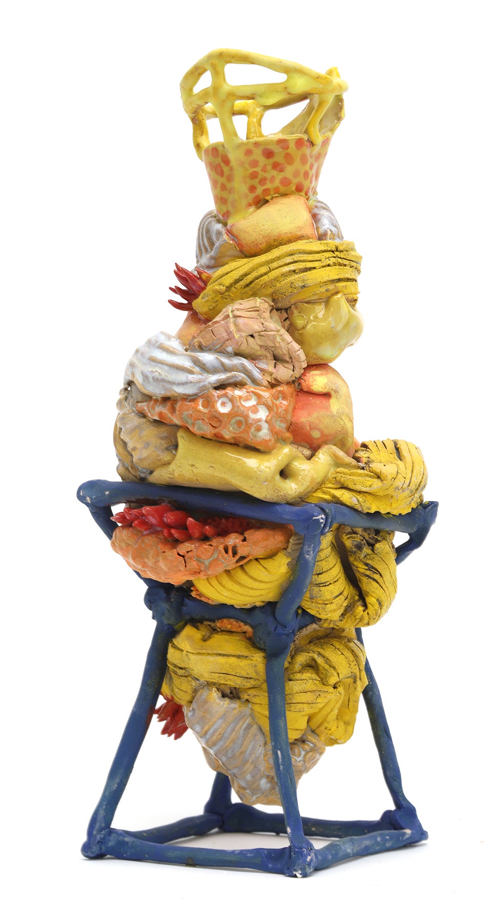 Squishy yellow ceramic form on blue coil structure. 