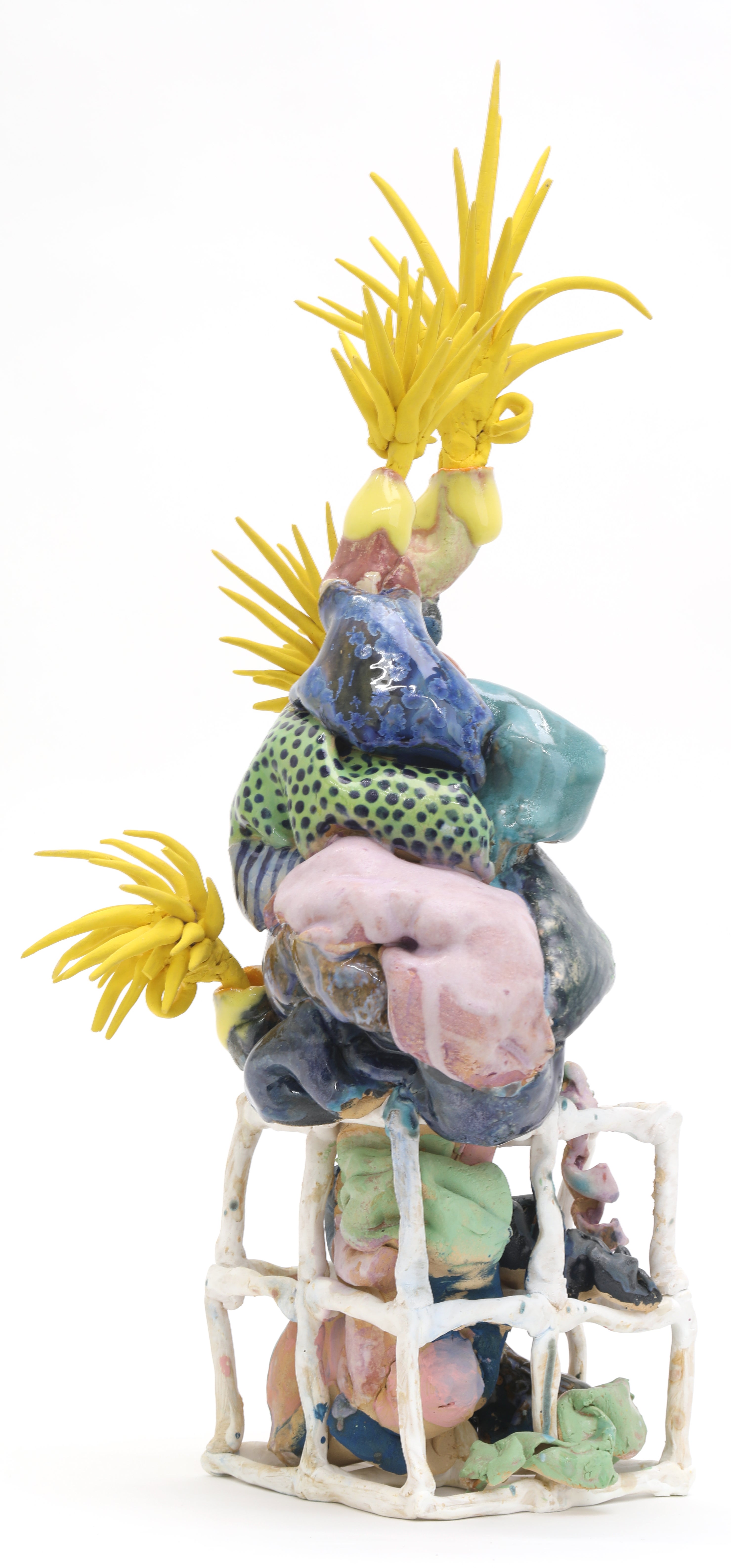 Squishy-looking multi-colored ceramic form rooting into square coil cubes with yellow spikey things on the ends. 