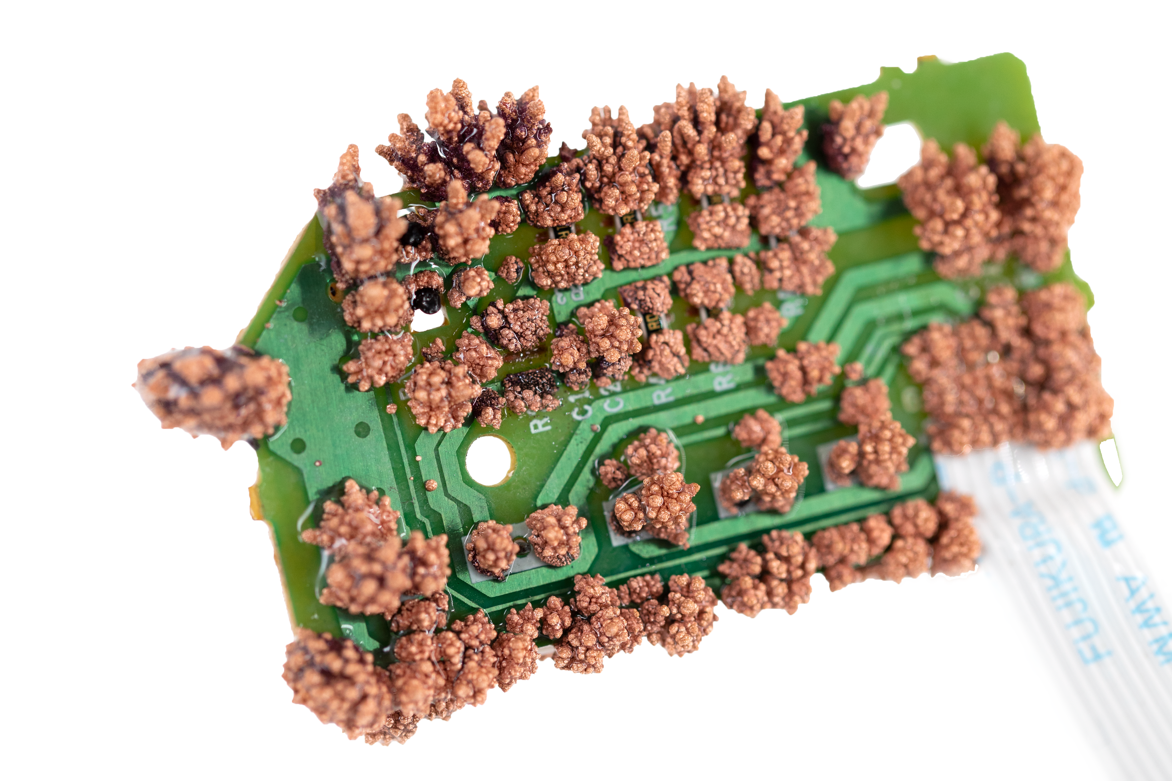 green circuit board with copper crystals growing on it
