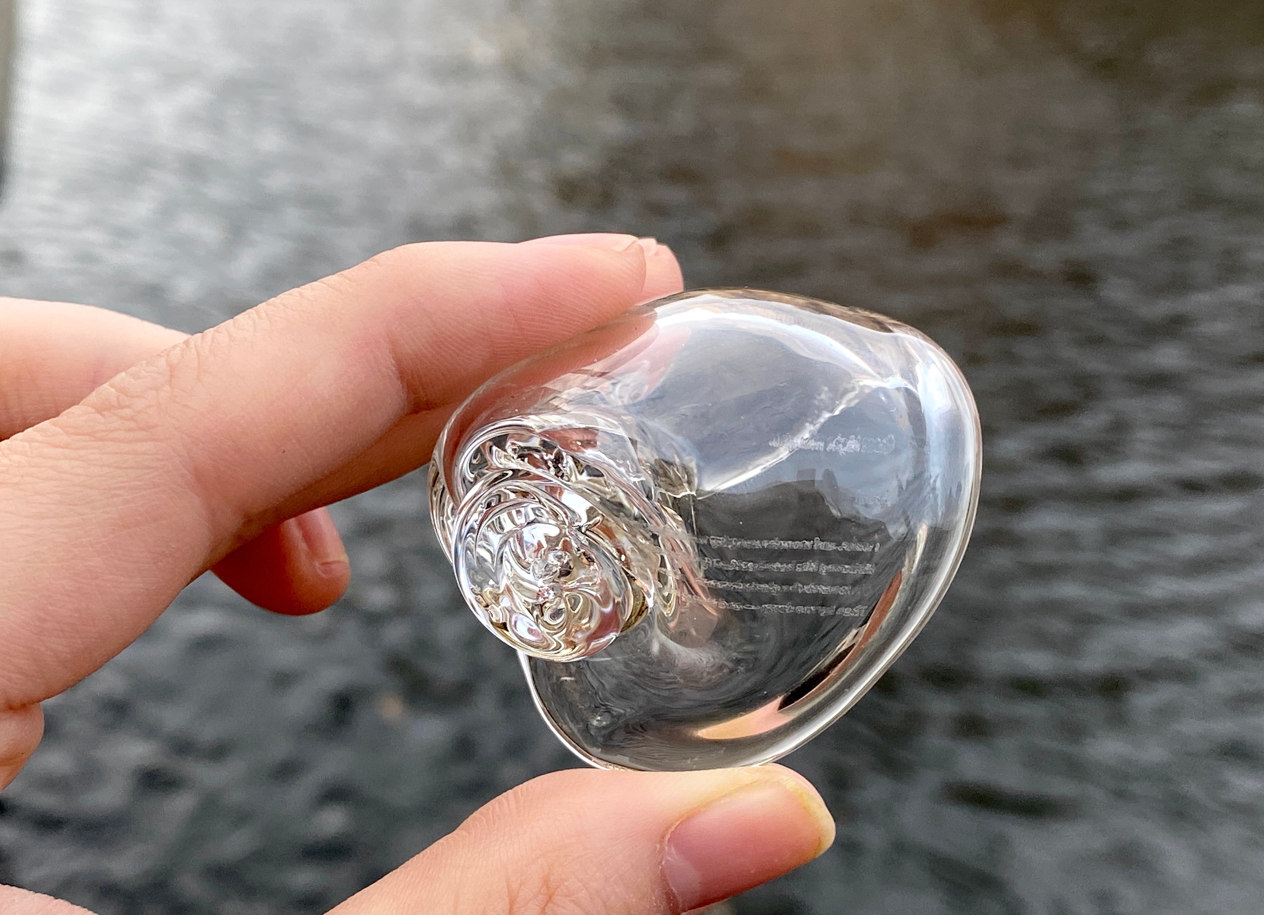 Hand hold a glass shell, you can see the poem on it 