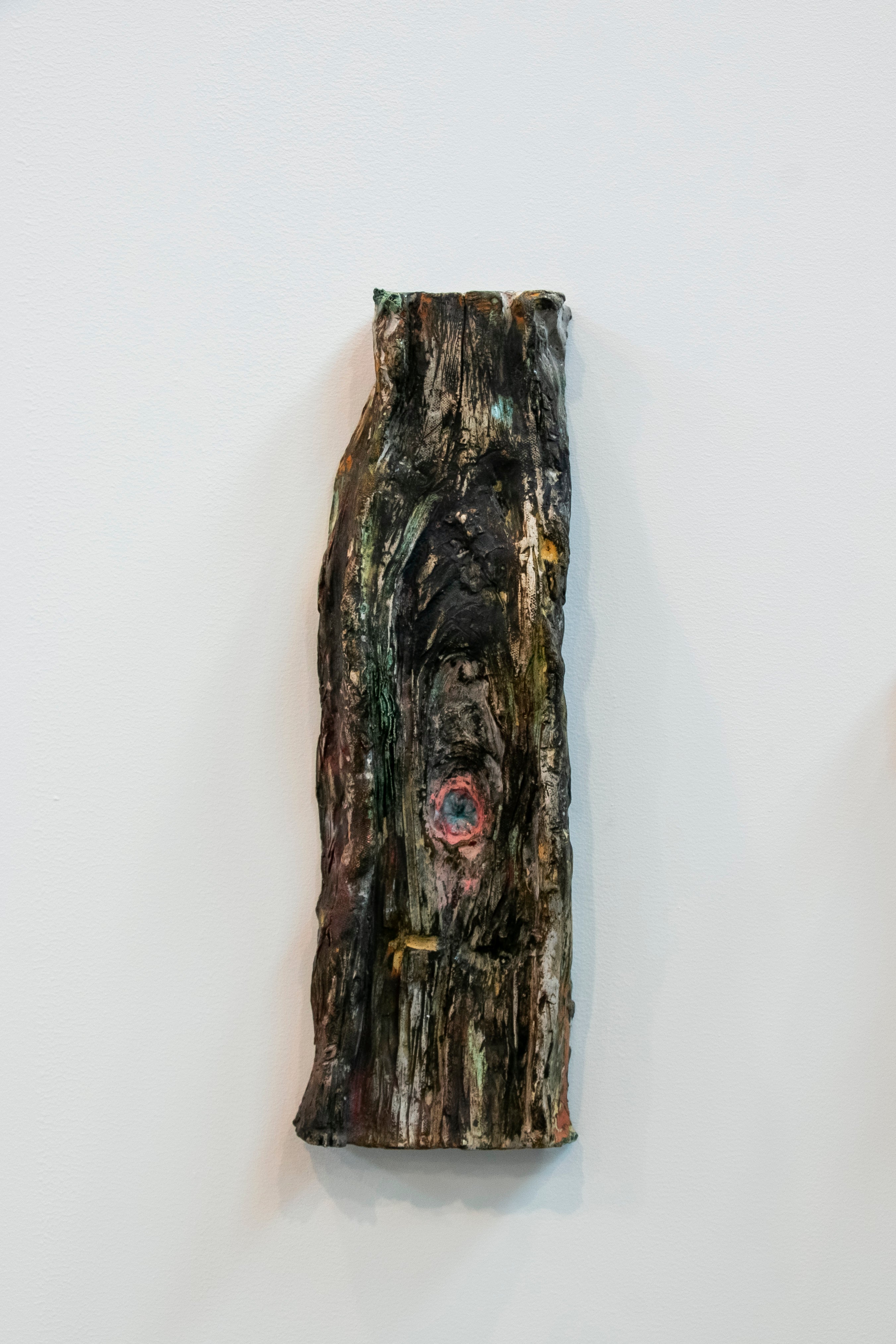 Sculpted slice of a tree with a pink asshole in the center.