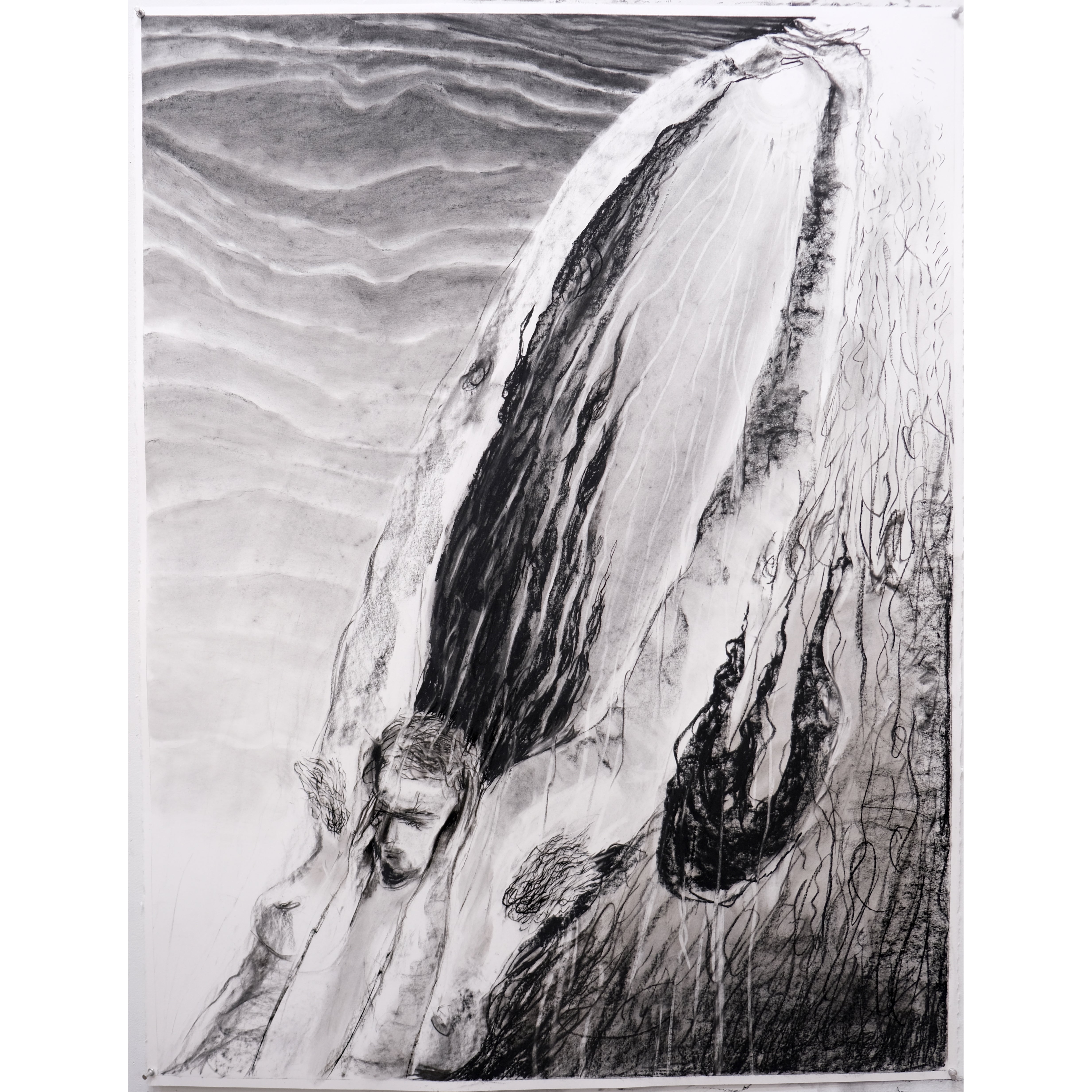 Photo of a charcoal drawing. The top half of a figure has arms that elongate diagonally upwards across the paper to cup a small moon. A darkly scrawled flame hovers.