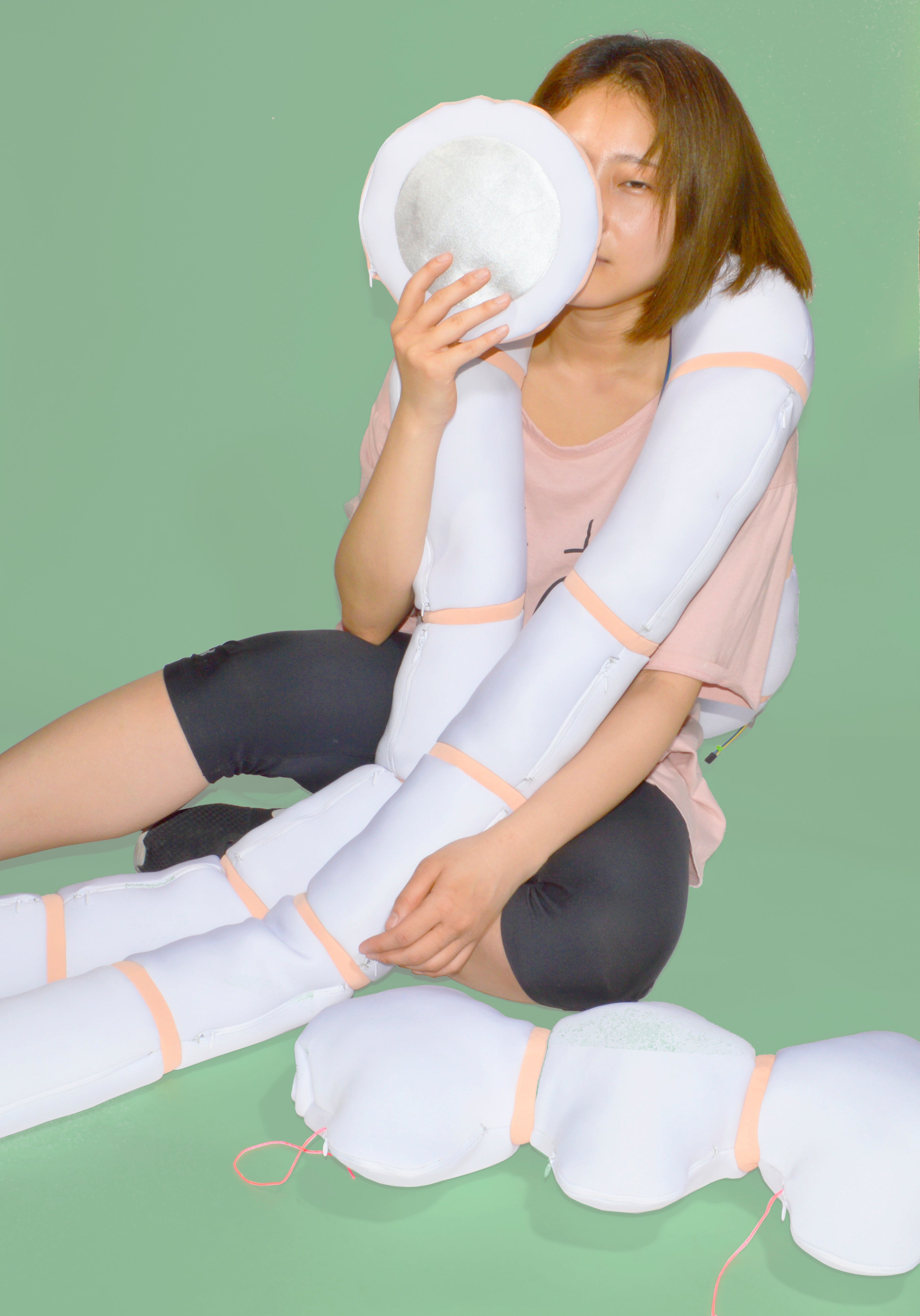 Color photograph, full body image with a girl holding the accessory of Nudo in green background