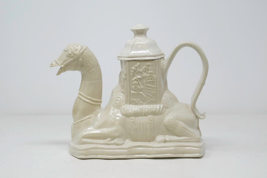 /A%20completely%20white%20earthenware%20camel%20shaped%20teapot%20with%20a%20hexagonal%20lid.