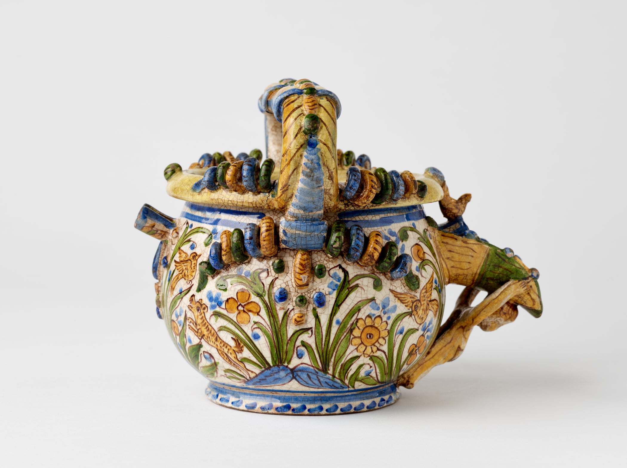 /A%20yellow%20ceramic%20jug%20with%20floral%20decorations%20that%20are%20blue%2C%20green%2C%20and%20yellow.%20
