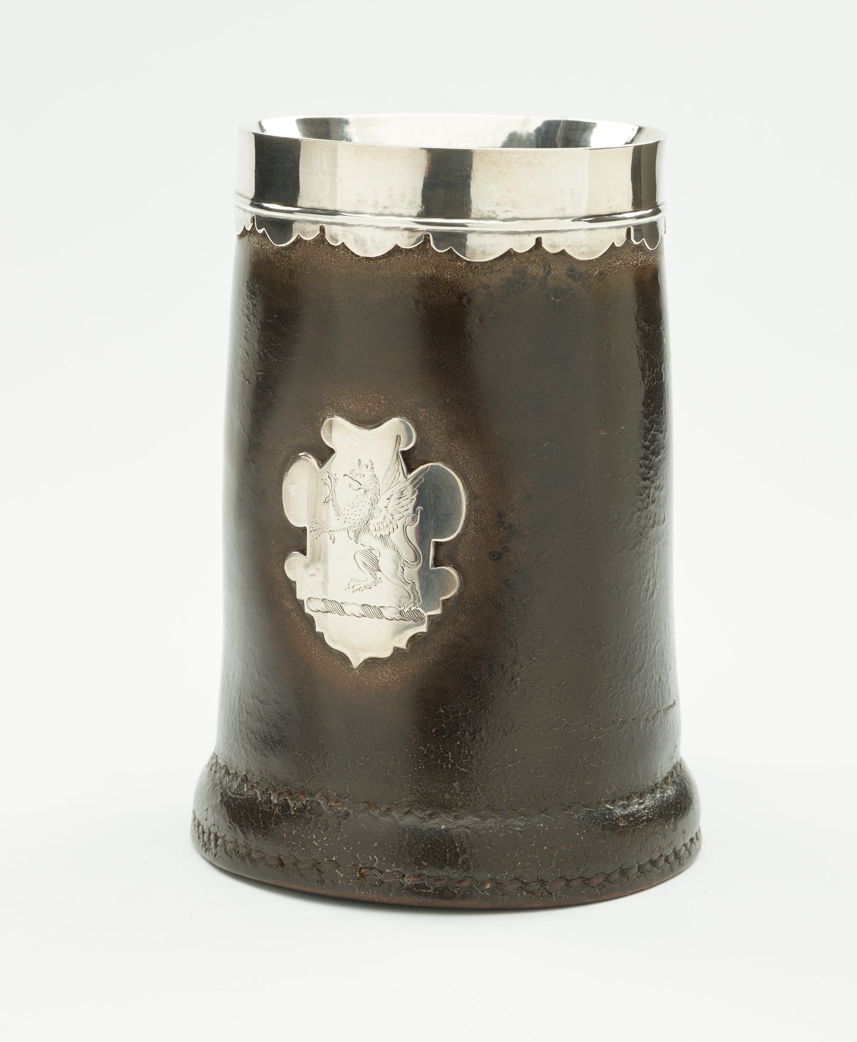 /BP%3A%20A%20leather%2C%20silver%2C%20and%20pewter%20tankard.%20The%20body%20is%20mostly%20dark%20with%20the%20exception%20of%20a%20decorative%20crest%2C%20rim%20and%20interior.%20