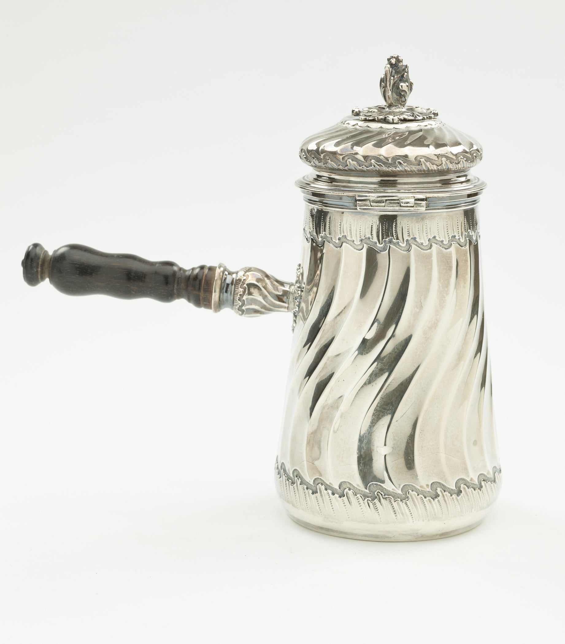 /A%20silver%20chocolate%20pot%20with%20a%20decorative%20swirled%20body%2C%20lid%2C%20and%20fruit%20wood%20handle.
