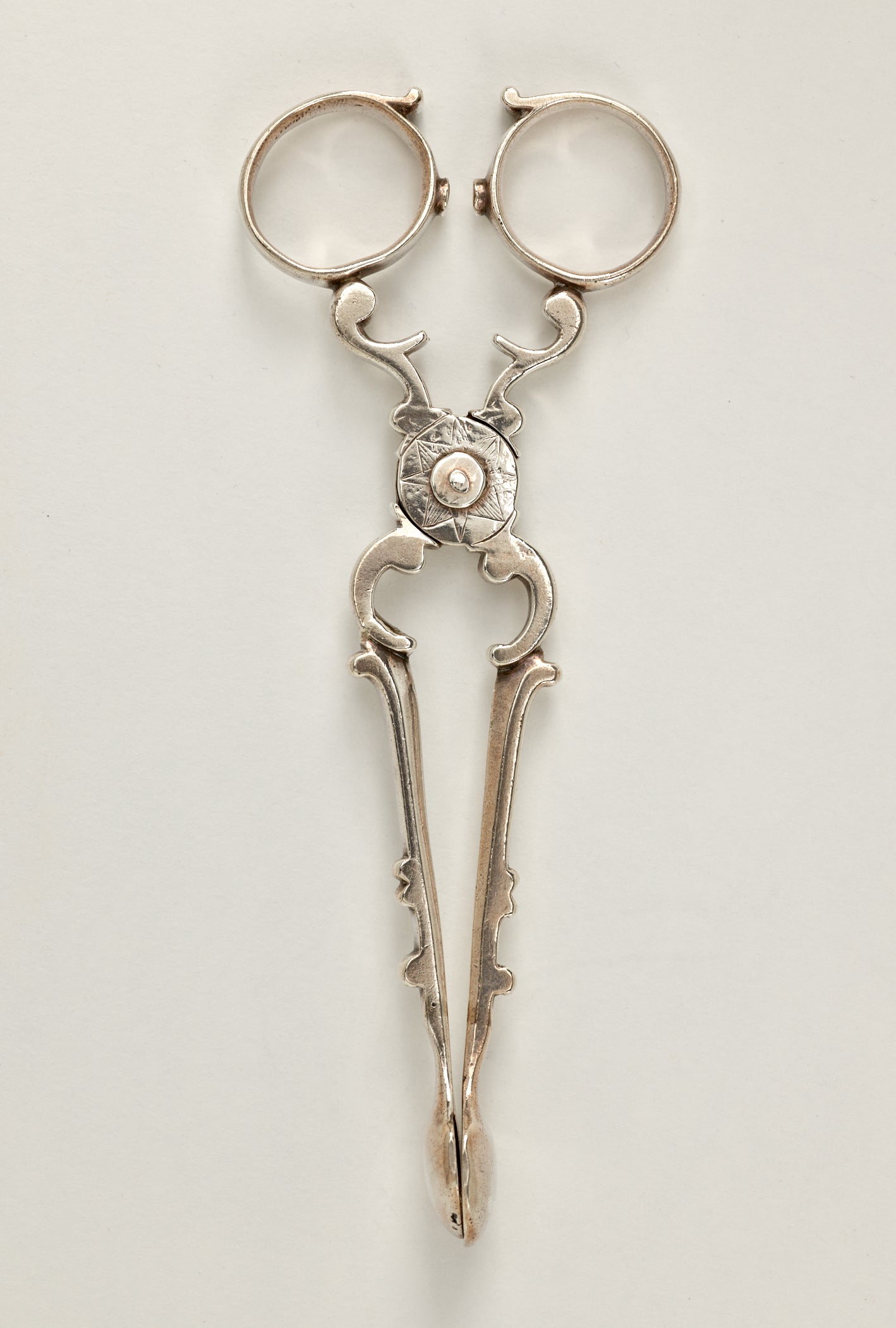 /Silver%20sugar%20tongs%20that%20are%20delicate%20and%20swirled.
