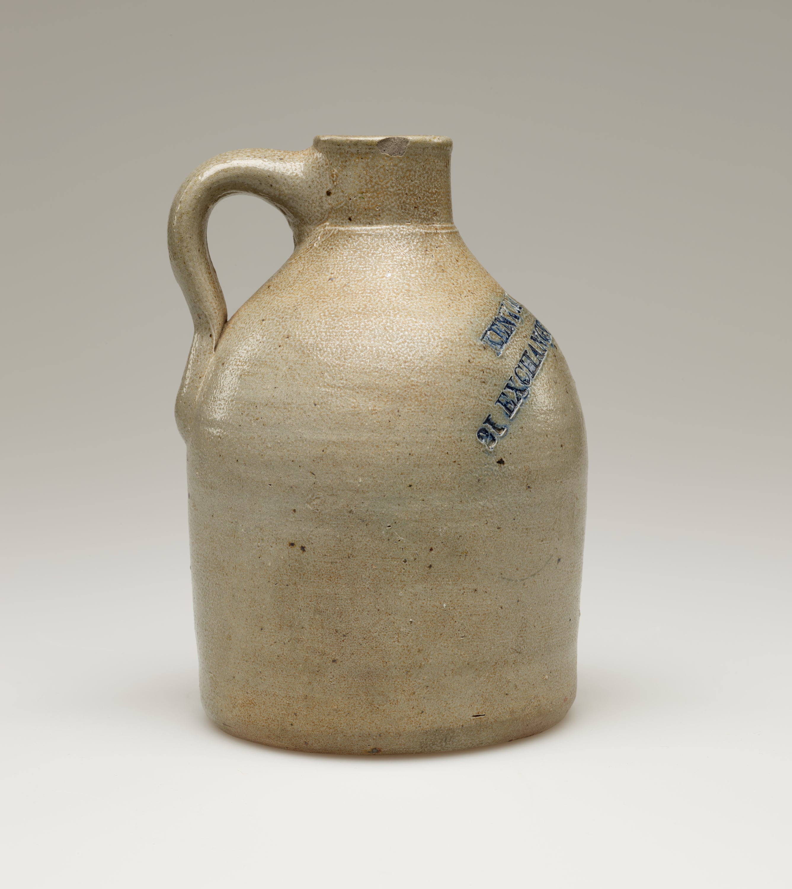 /A%20round%2C%20sand%20colored%20jug%20with%20a%20small%2C%20rounded%20handle.%20Blue%20colored%20text%20%20is%20stamped%20into%20the%20body%20of%20the%20jug%2C%20on%20the%20left%20side.%20Legible%20text%20reads%2C%20%E2%80%9CPROV%20RI.%E2%80%9D
