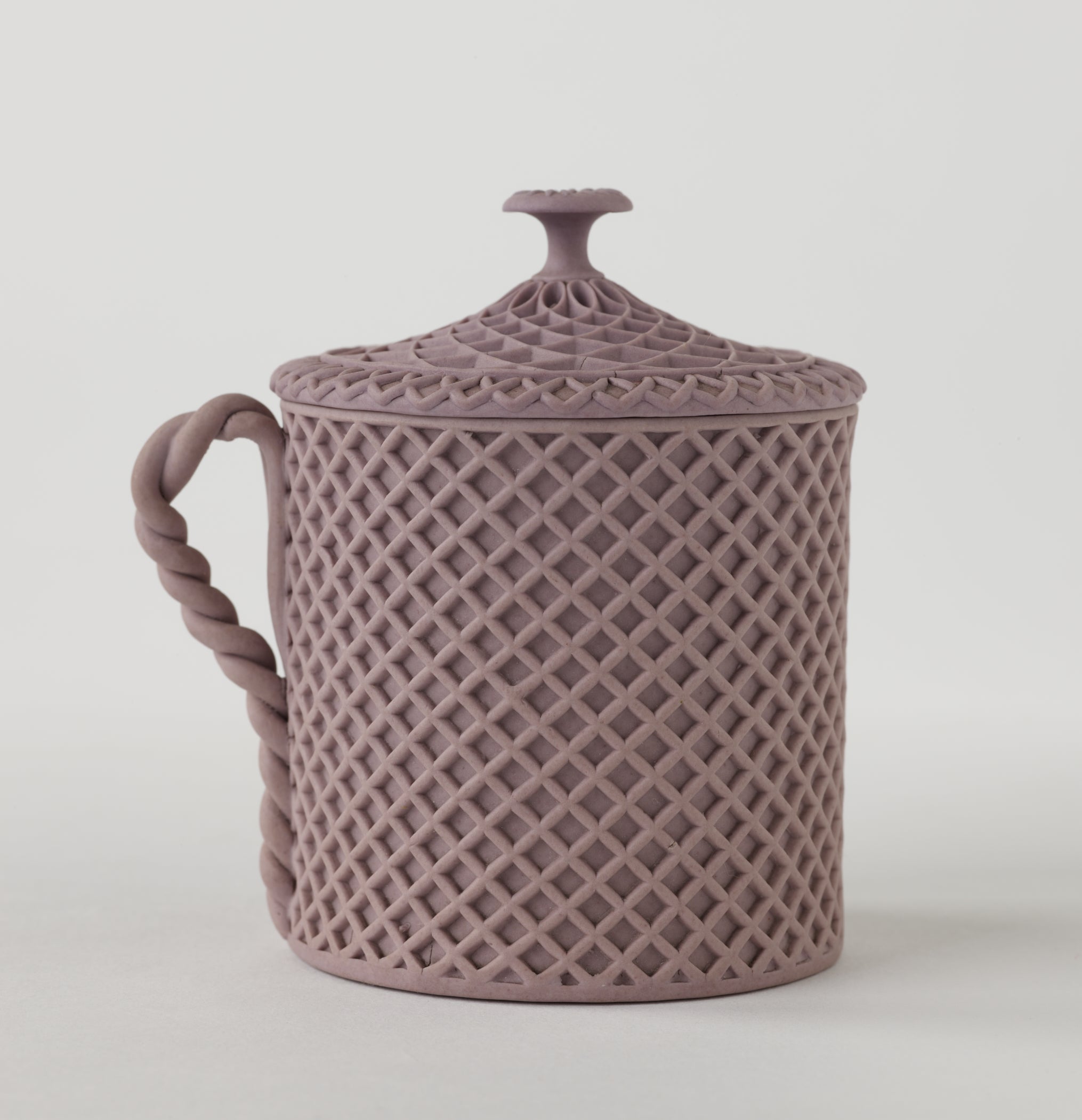 /Jasperware%20custard%20cup%20with%20cover%2C%20the%20entire%20vessel%20and%20lid%20has%20a%20raised%20woven%20texture.%20The%20handle%20is%20sculptural%20and%20swirled.