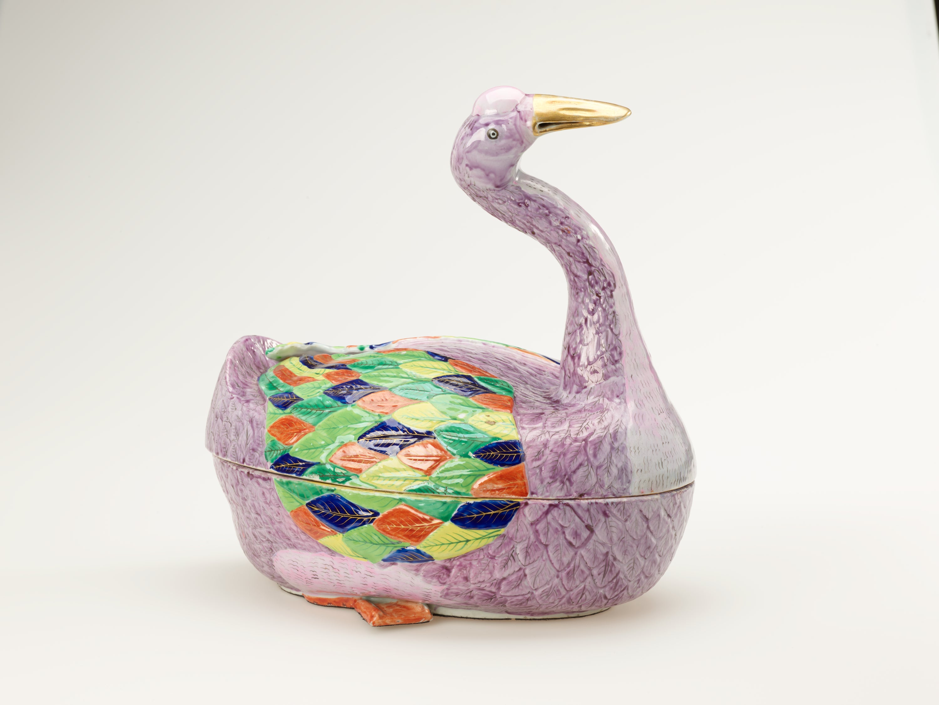 /A%20sculptural%20vessel%20in%20the%20shape%20of%20a%20goose.%20The%20purple%20body%20is%20accented%20with%20diamond-shaped%20decorations%20in%20green%2C%20blue%2C%20yellow%2C%20and%20orange.
