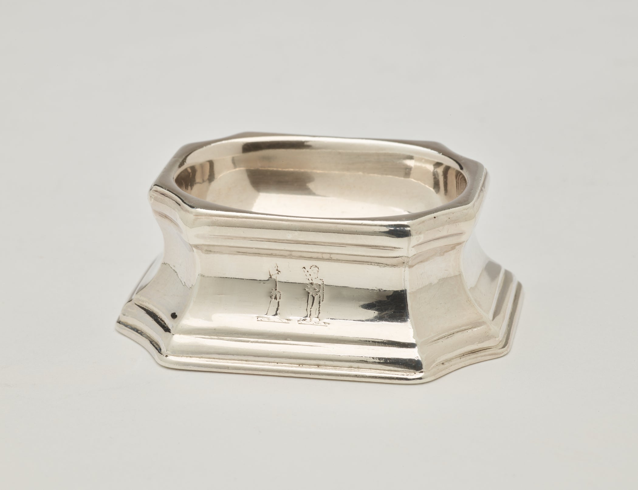 /A%20silver%20salt%20container%20that%20is%20rounded%20on%20the%20inside%20and%20angular%20on%20the%20outside.%20