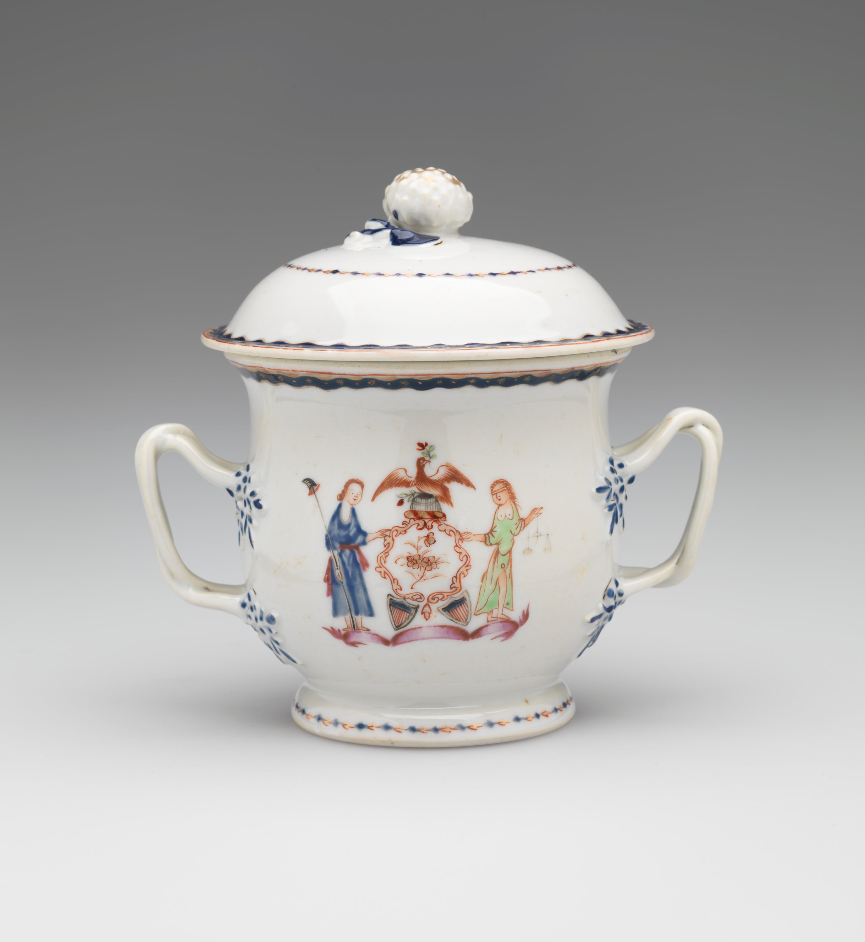 /A%20white%20vessel%20with%20two%20symmetrical%20handles%20with%20blue%20decorations%2C%20heraldry%20imagery%2C%20two%20figures%20with%20light%20hair.%20One%20holding%20a%20staff%20and%20the%20other%20is%20blindfold%20and%20holding%20scales.
