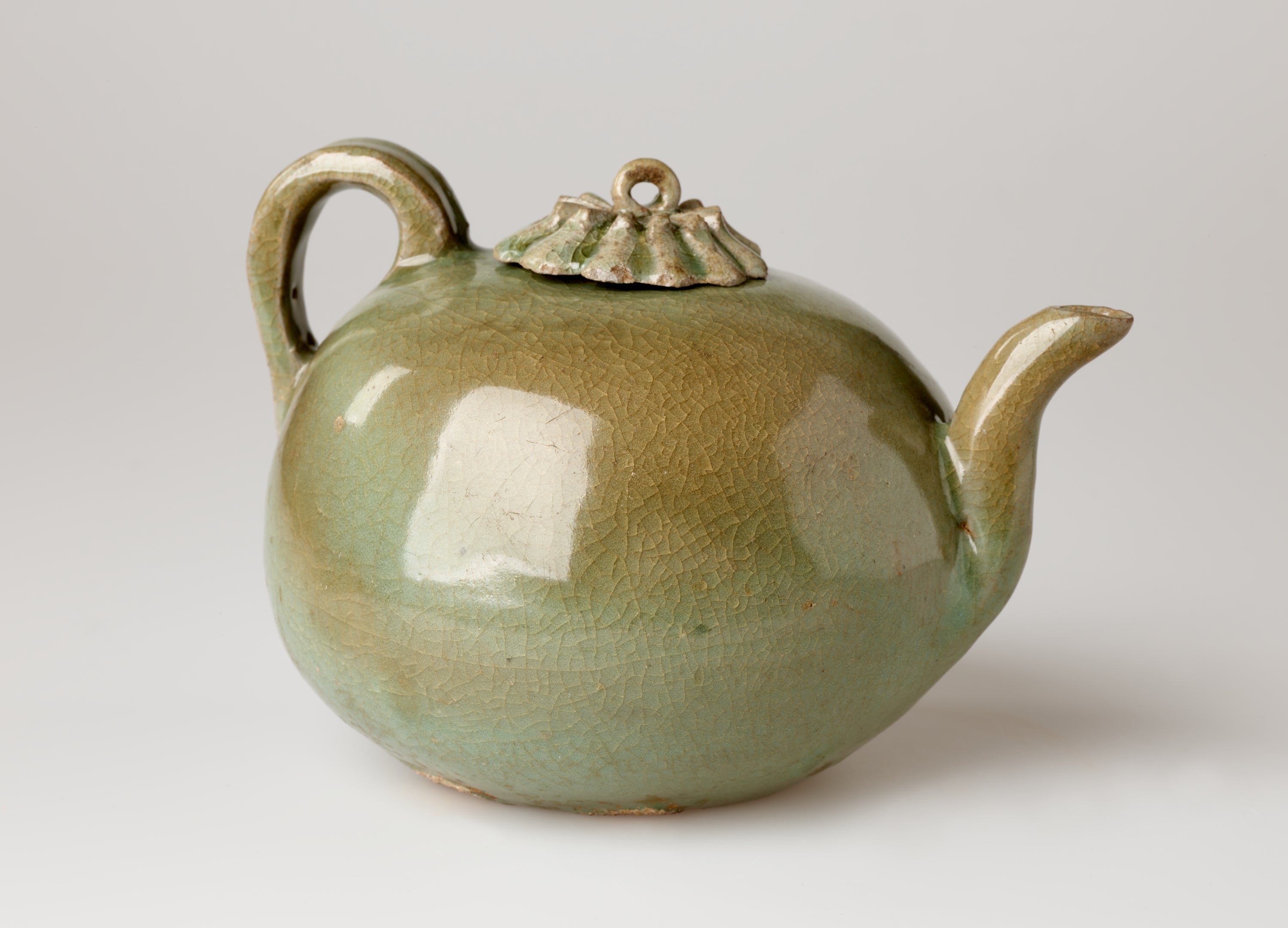 /A%20rounded%20greenish%20brown%20water%20kettle%20with%20a%20handle%2C%20spout%2C%20and%20small%20decorative%20lid%20and%20a%20loop%20for%20a%20finial.%20