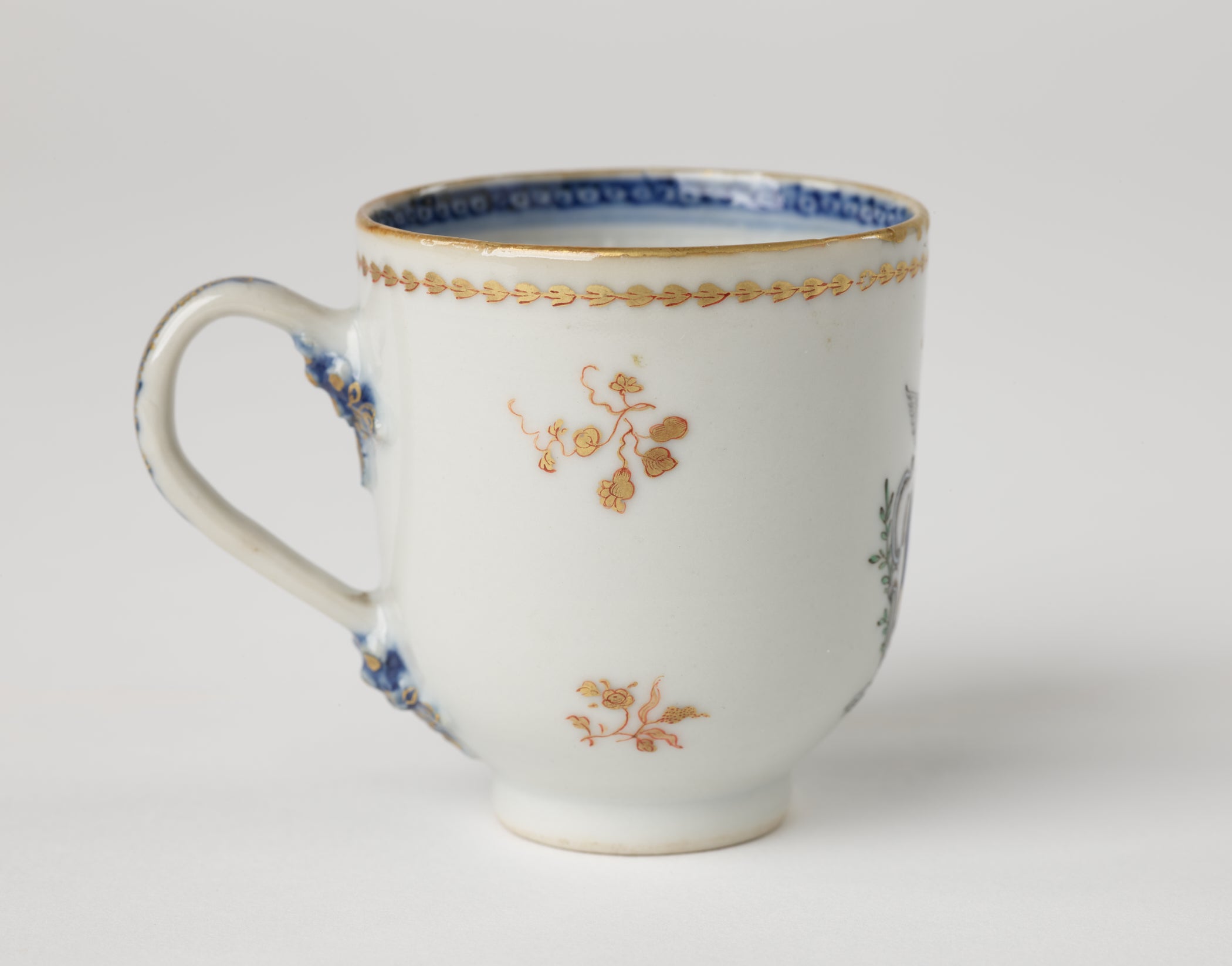 /A%20porcelain%20chocolate%20cup%20with%20blue%20and%20gilded%20decorations%20along%20the%20outside%20and%20inside%20of%20the%20rim%2C%20body%2C%20and%20handle.%20