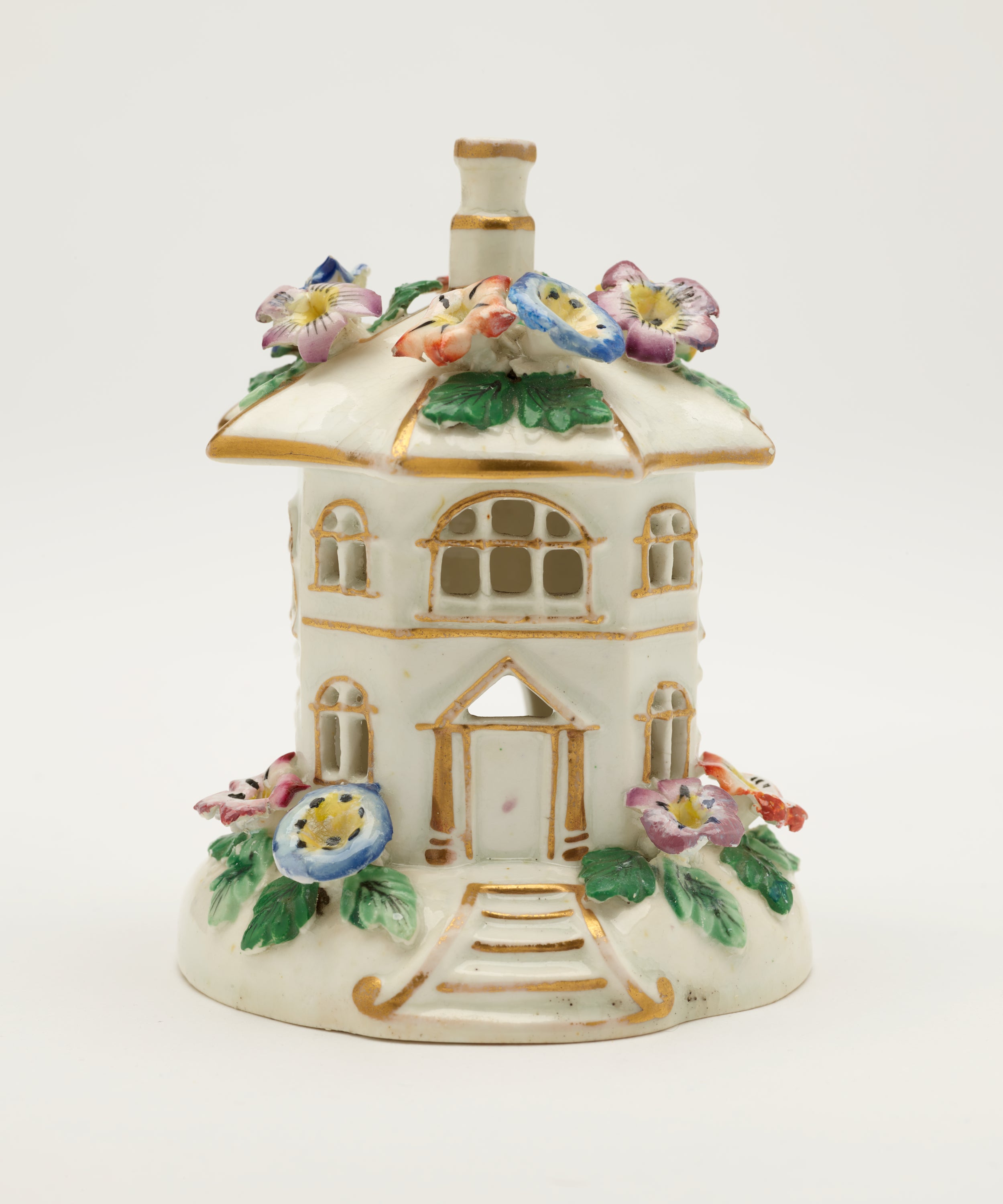 /A%20sculpture%20in%20the%20shape%20of%20a%20small%20white%20house%2C%20covered%20in%20different%20colored%20flowers.