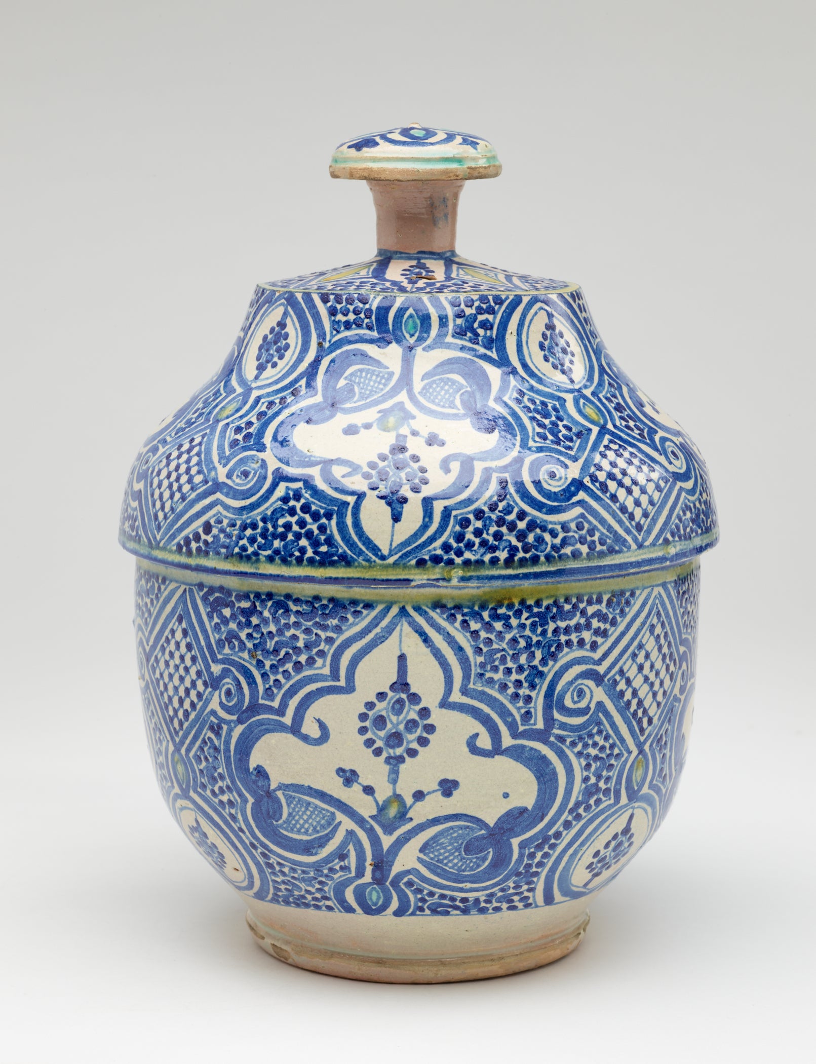 /A%20gray-white%20lidded%20bowl%20with%20delicate%20blue%20symmetrical%20decorations%20and%20a%20finial%20with%20turquoise%20decorations.