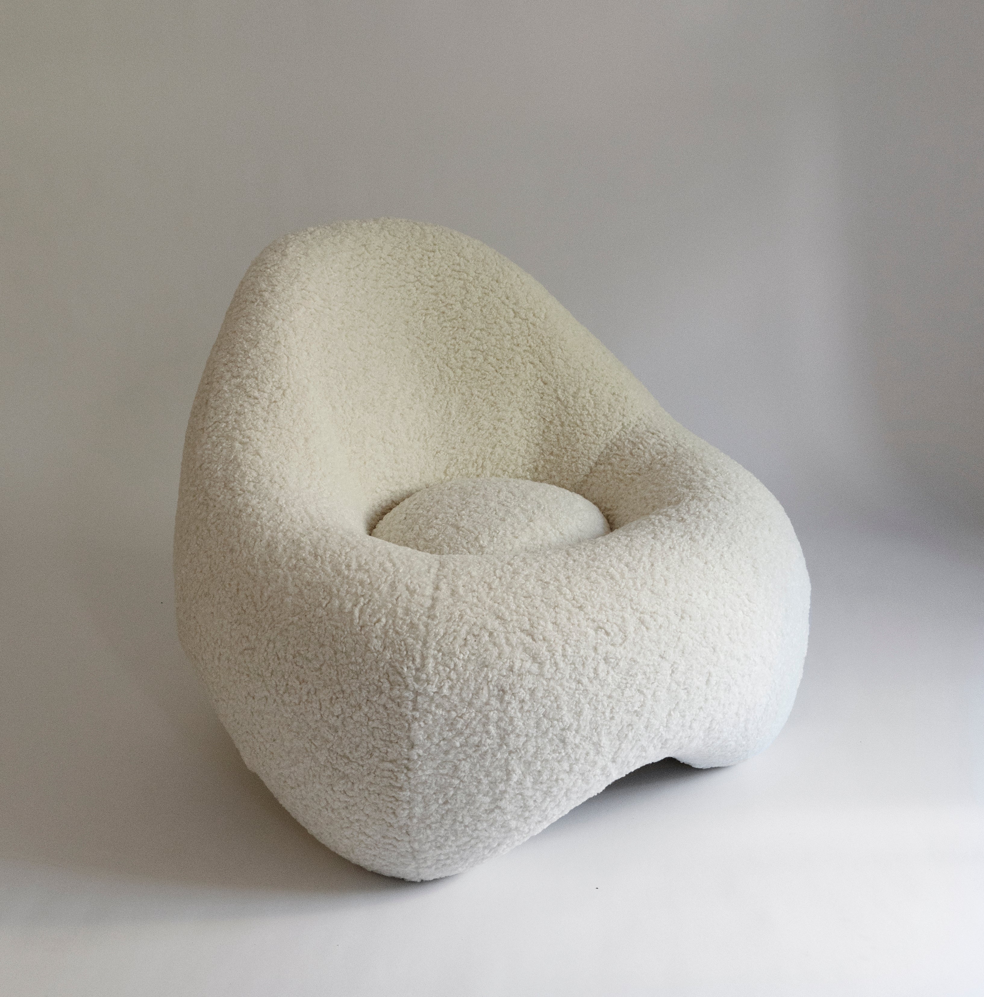 a soft, frame-less shape low lounge chair upholstered in sherpa