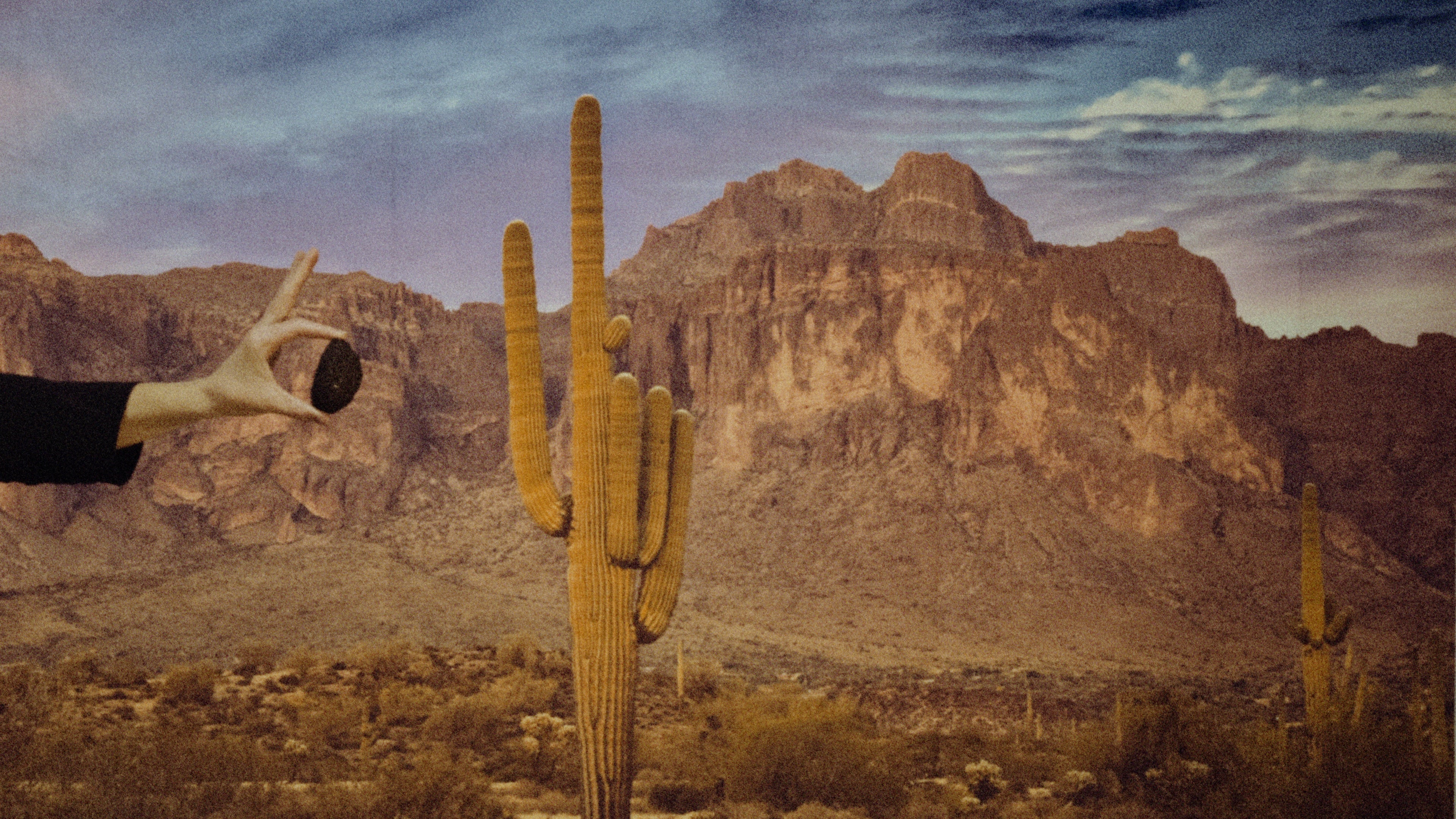 A western background with a hand holding a piece of coal. 