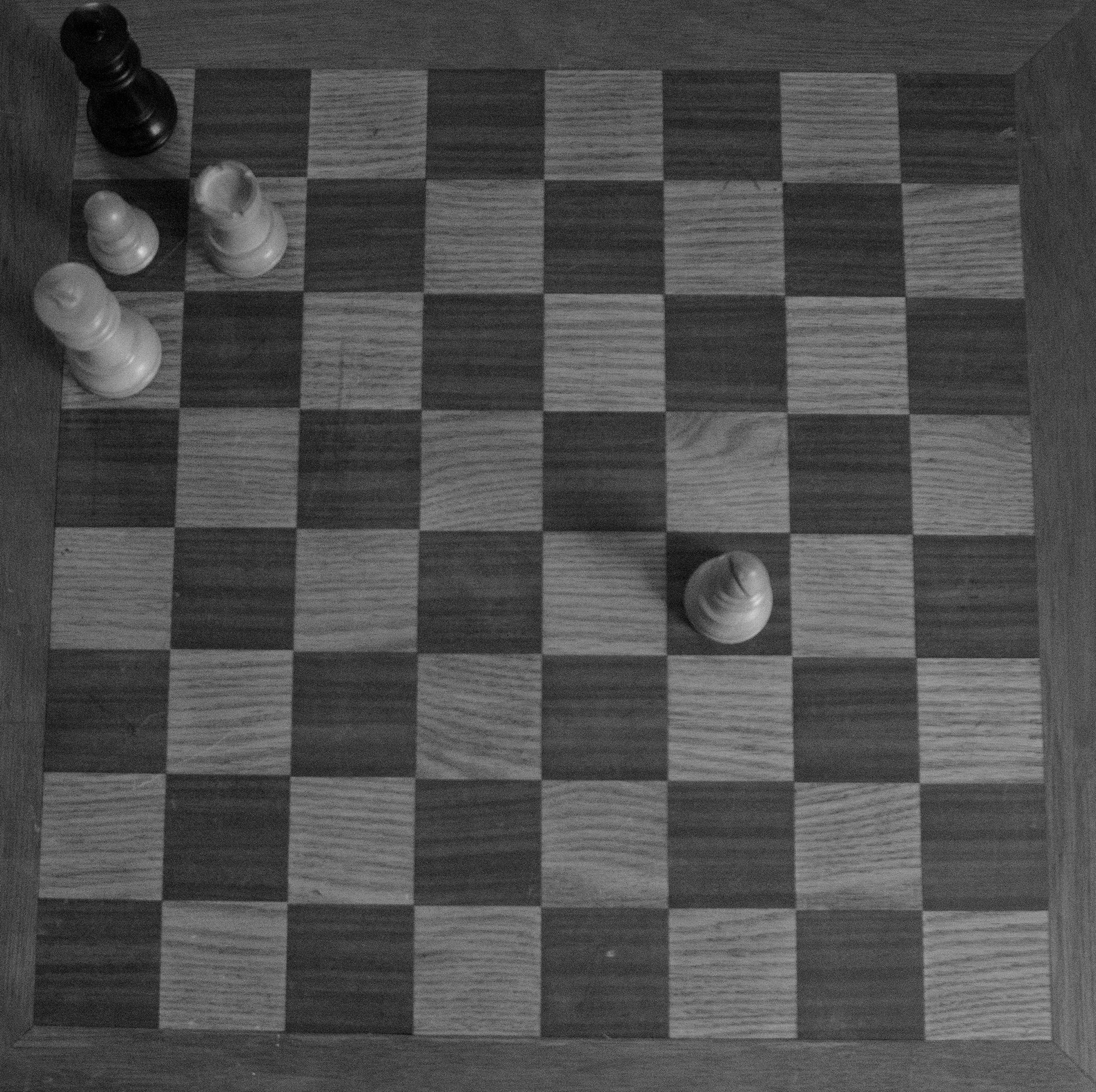 Hand made chess board with pieces displaying a stale mate.