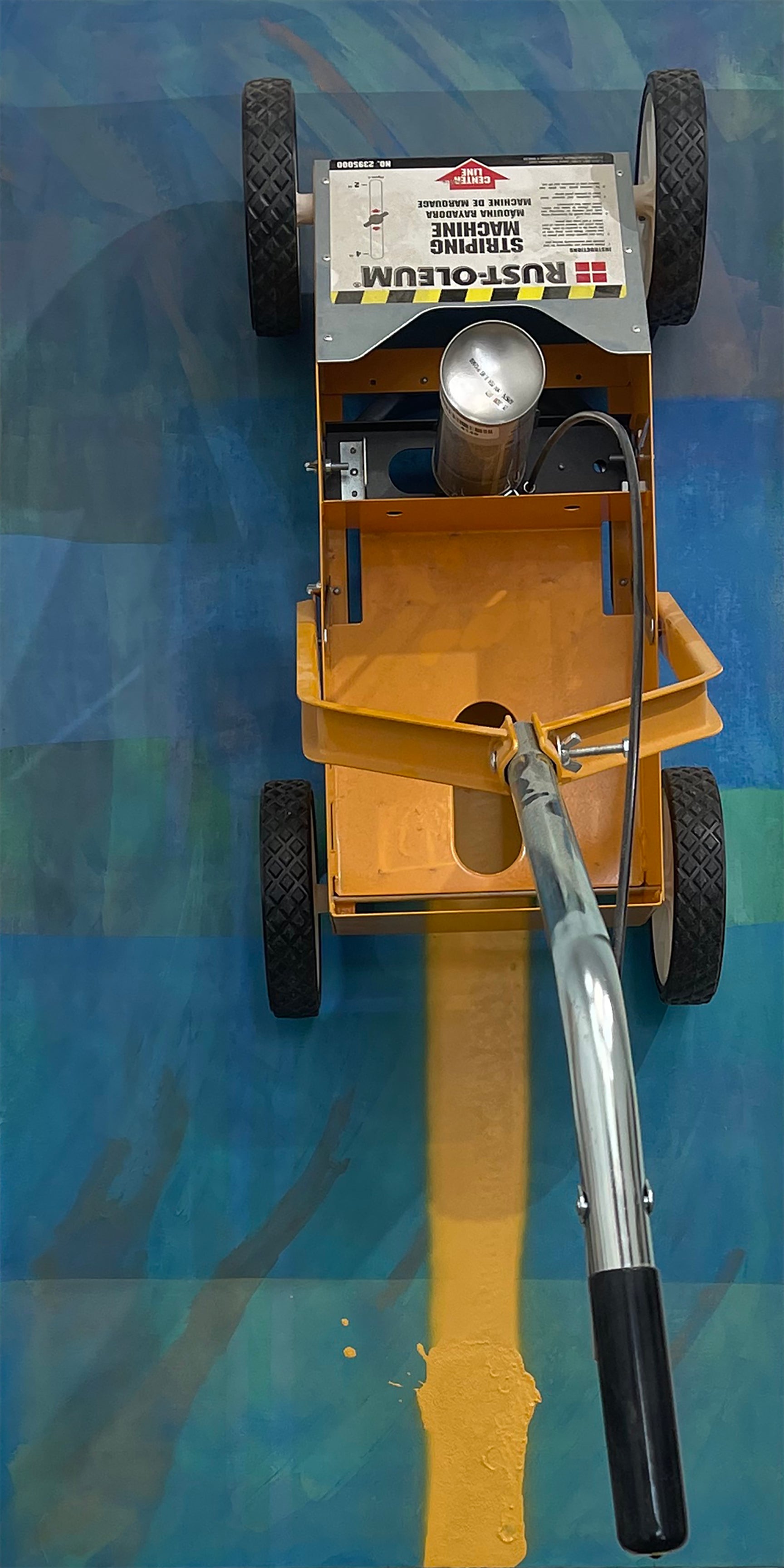 Abstract painting with parking lot line drawing tool attached vertically.  It has finished drawing half across the painting