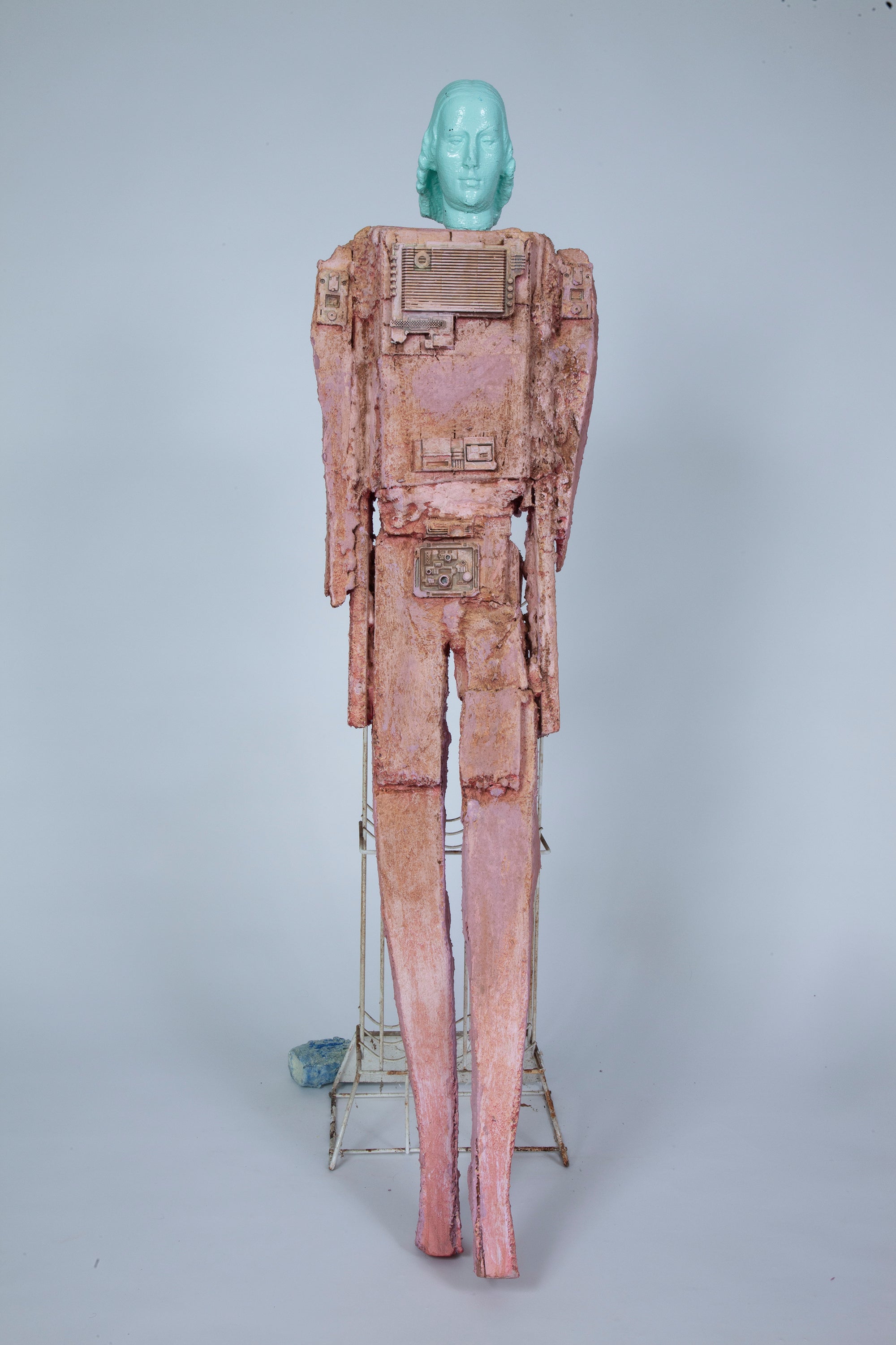pink robotic figure leaning on wine rack