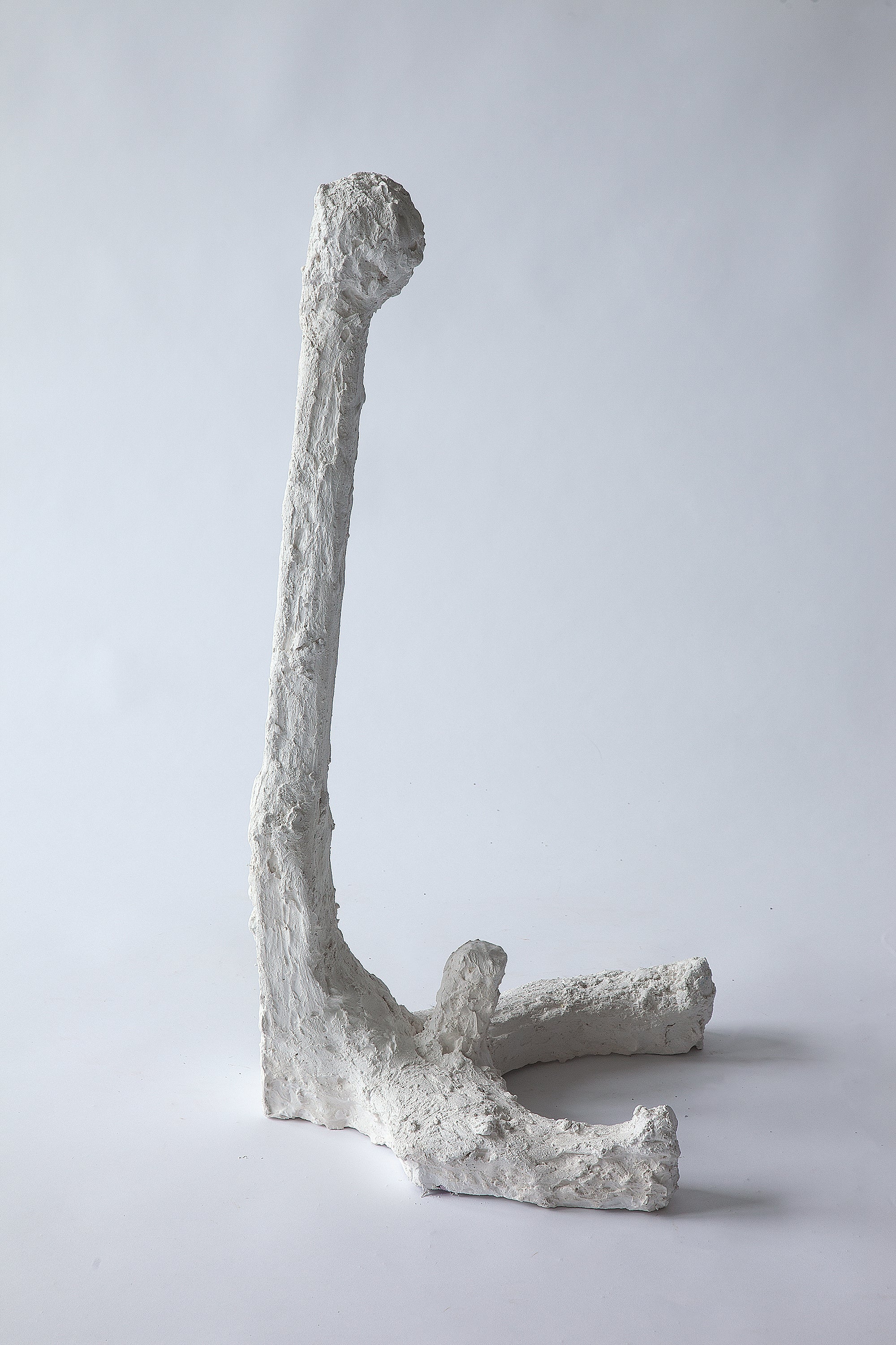 Plaster figure with a long neck and erect phallus