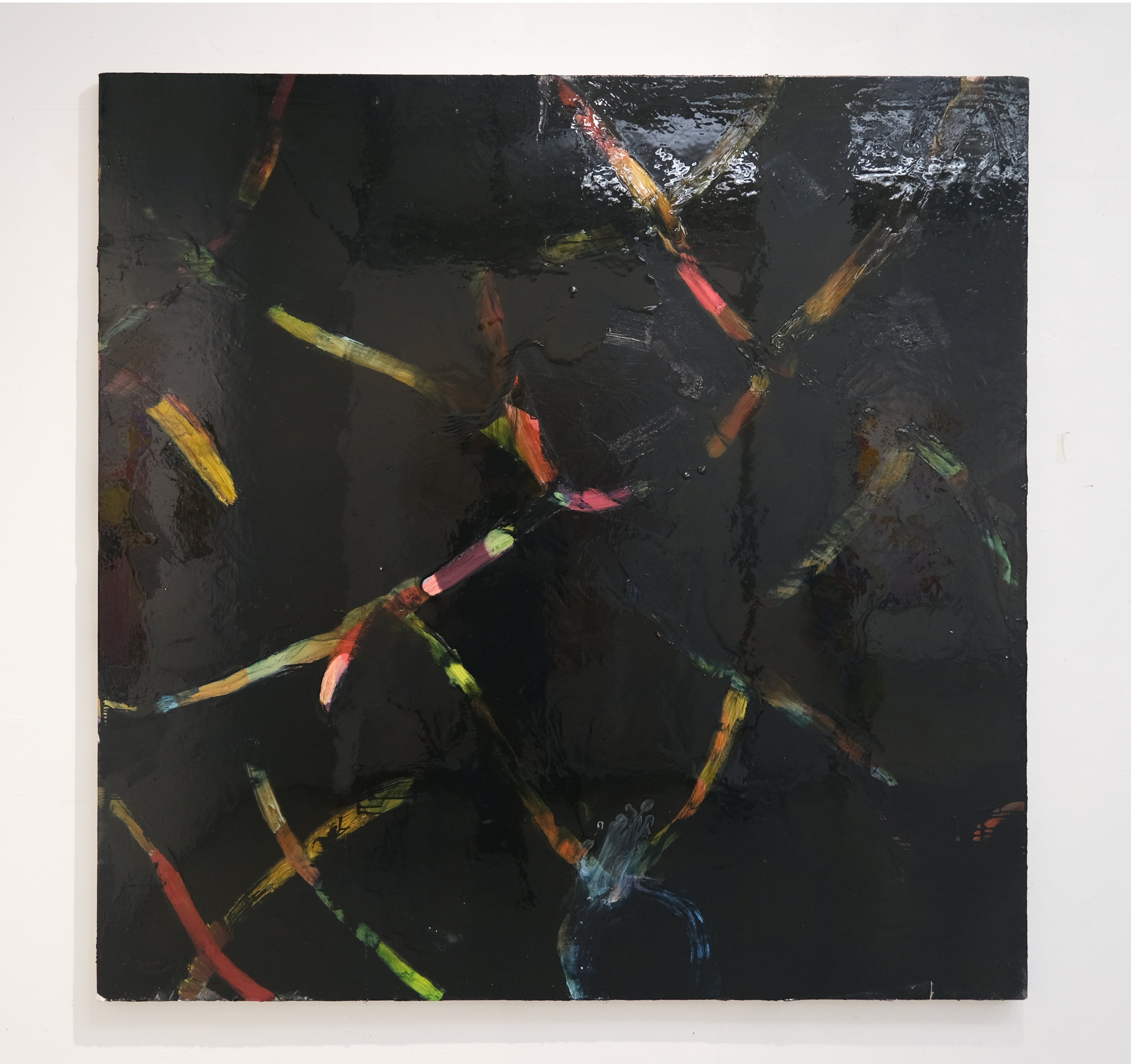 A shiny black square-ish canvas with strokes of pink, blue, ochre, and green.  