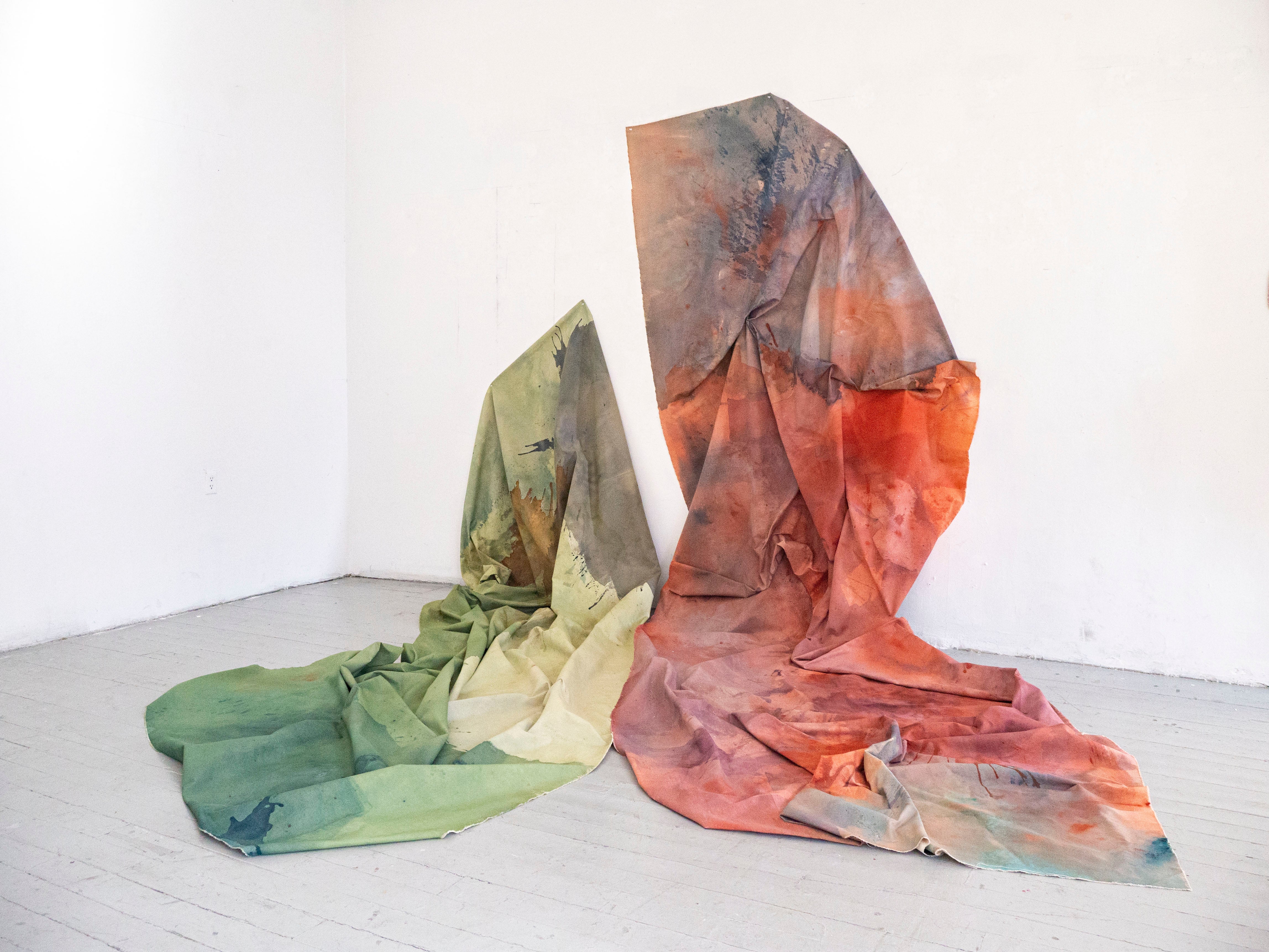 Large folded canvas, gathered and hand sewn together like fabric pouring from partially up the wall to the floor abstracting in the shape of a butterfly.