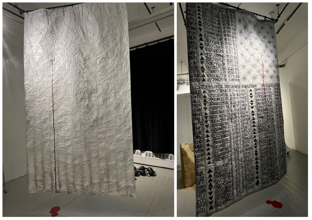 Gone But Not Forgotten? is a 10-foot-tall painted all-white United States flag that is hung up vertically to the ceiling and freely draping down. There's a visible bullet hole stain on both sides. And a dark red bloodline flows down from it, making a red puddle on the floor.