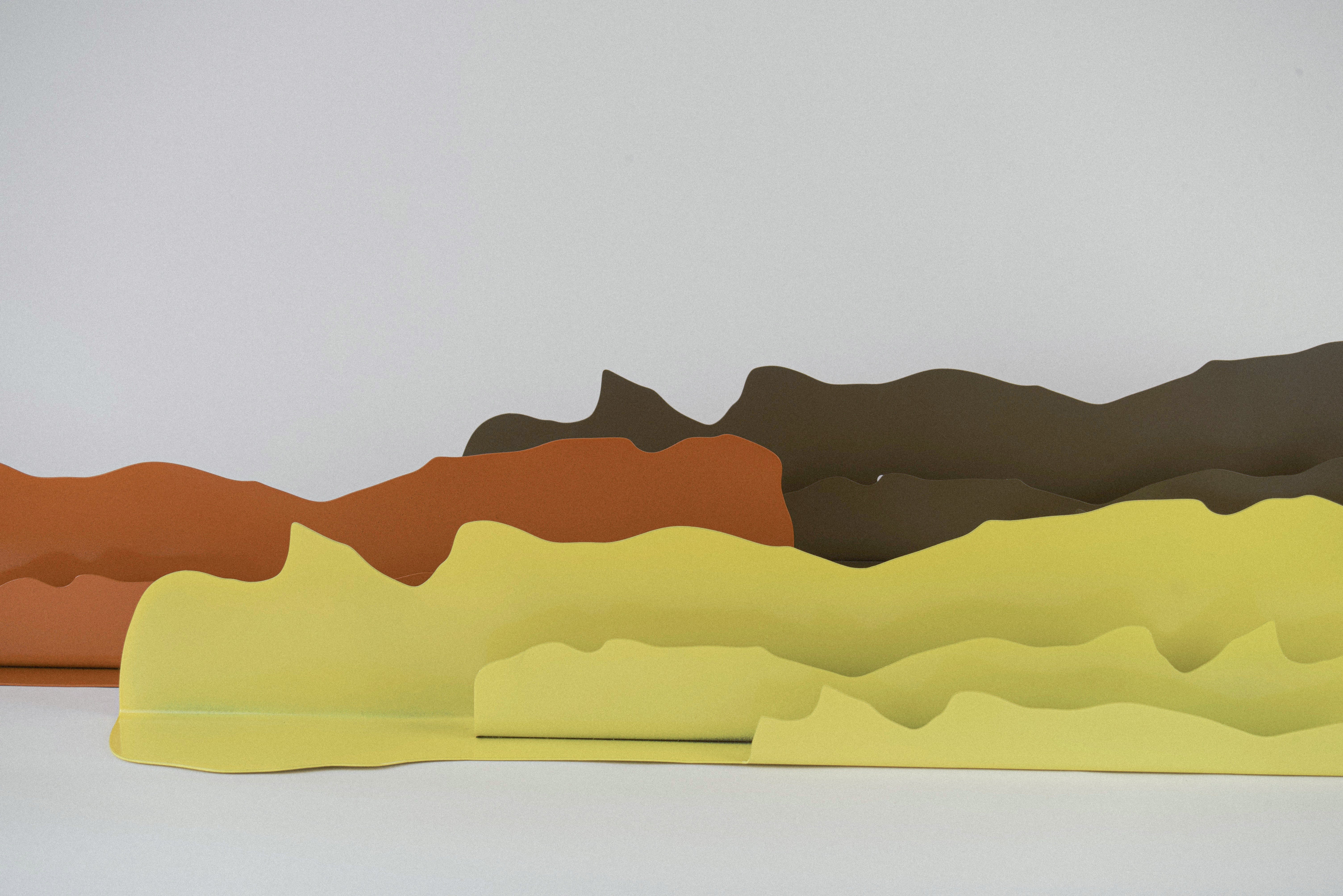 A collection of three steel wall mounted shelves. 