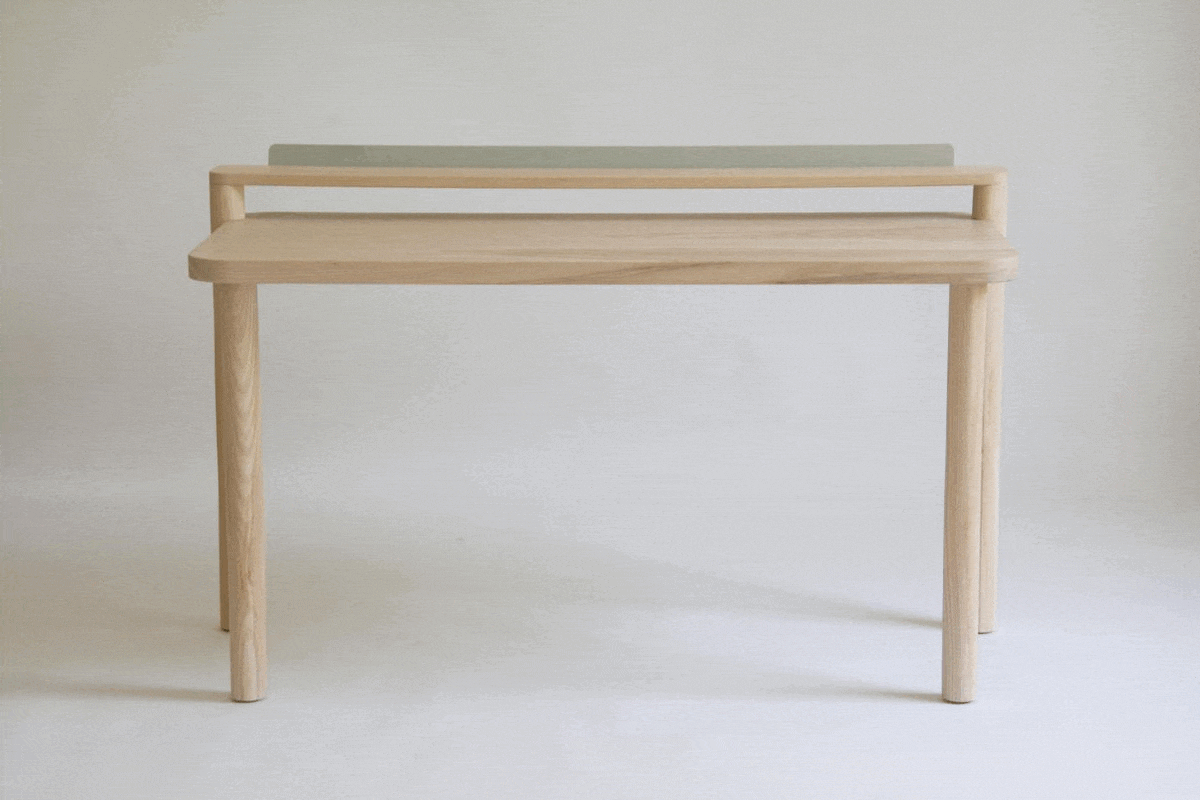 A moving .gif image showing a sequence of postcards being added to the ledge of a solid wood desk. 