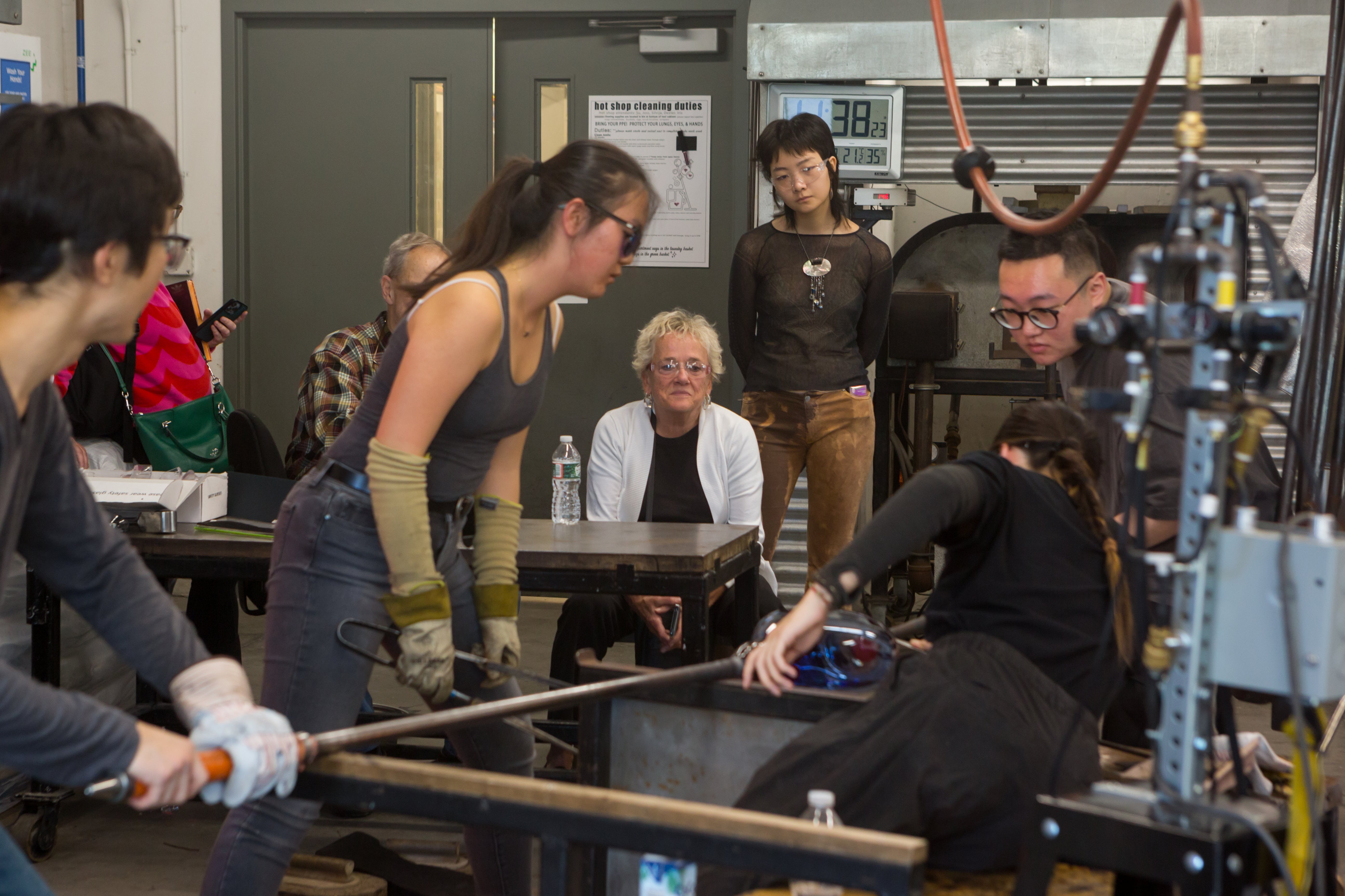 /Four%20students%20work%20together%20in%20a%20glass%20blowing%20demonstration.