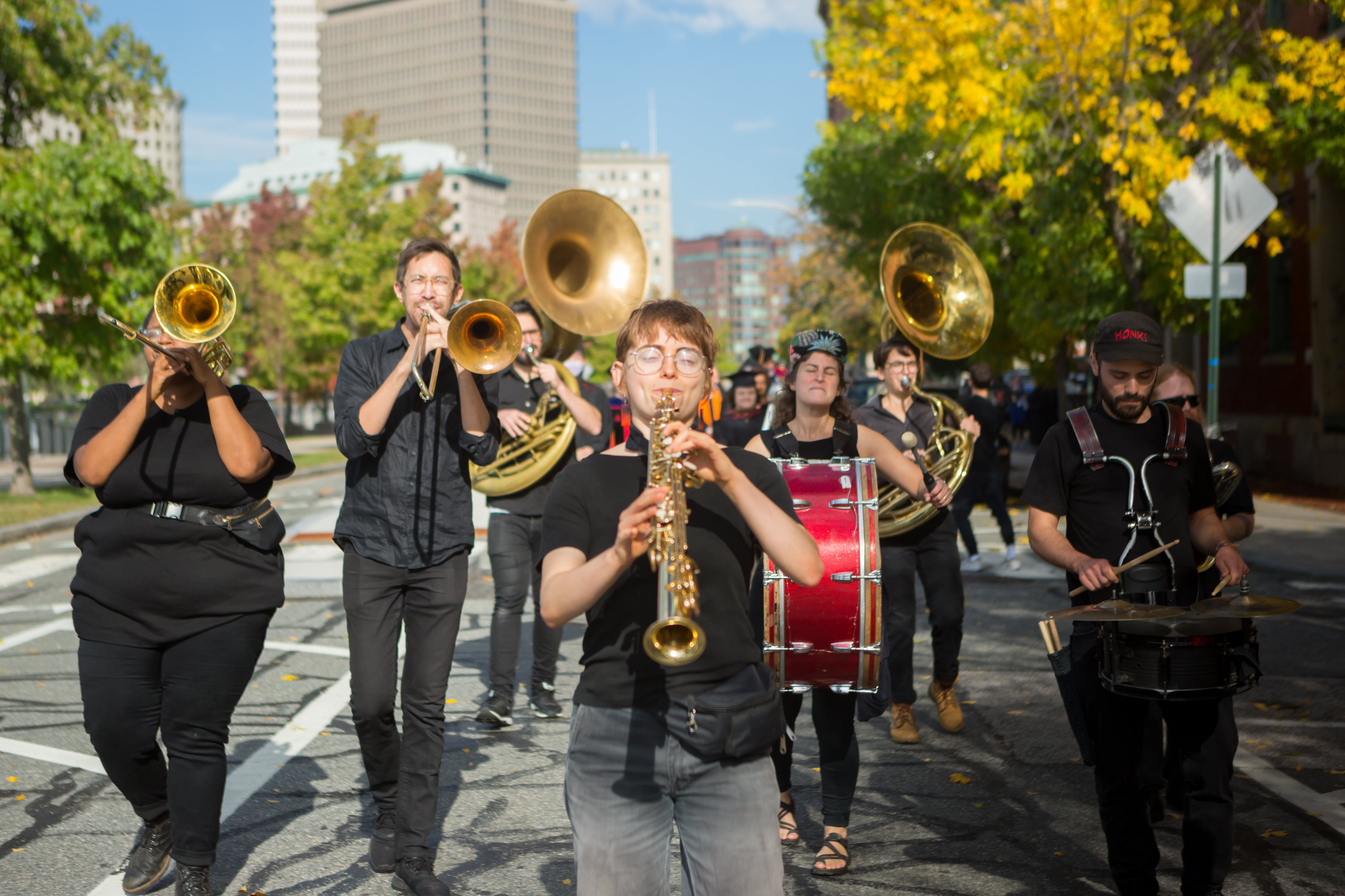 /A%20small%20brass%20band%20walks%20through%20a%20tree-lined%20street