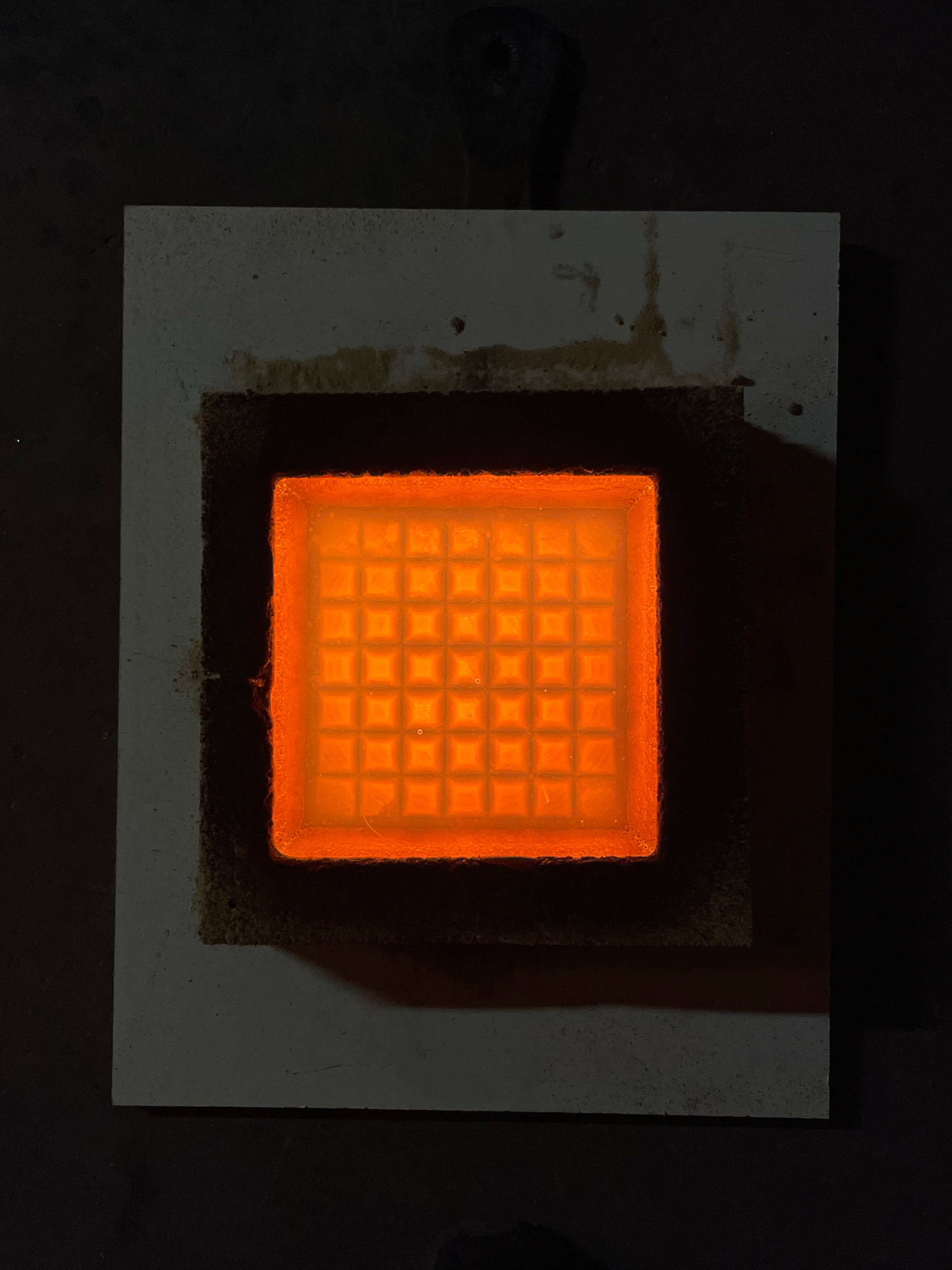 Molten glass poured into an optical grid mold.
