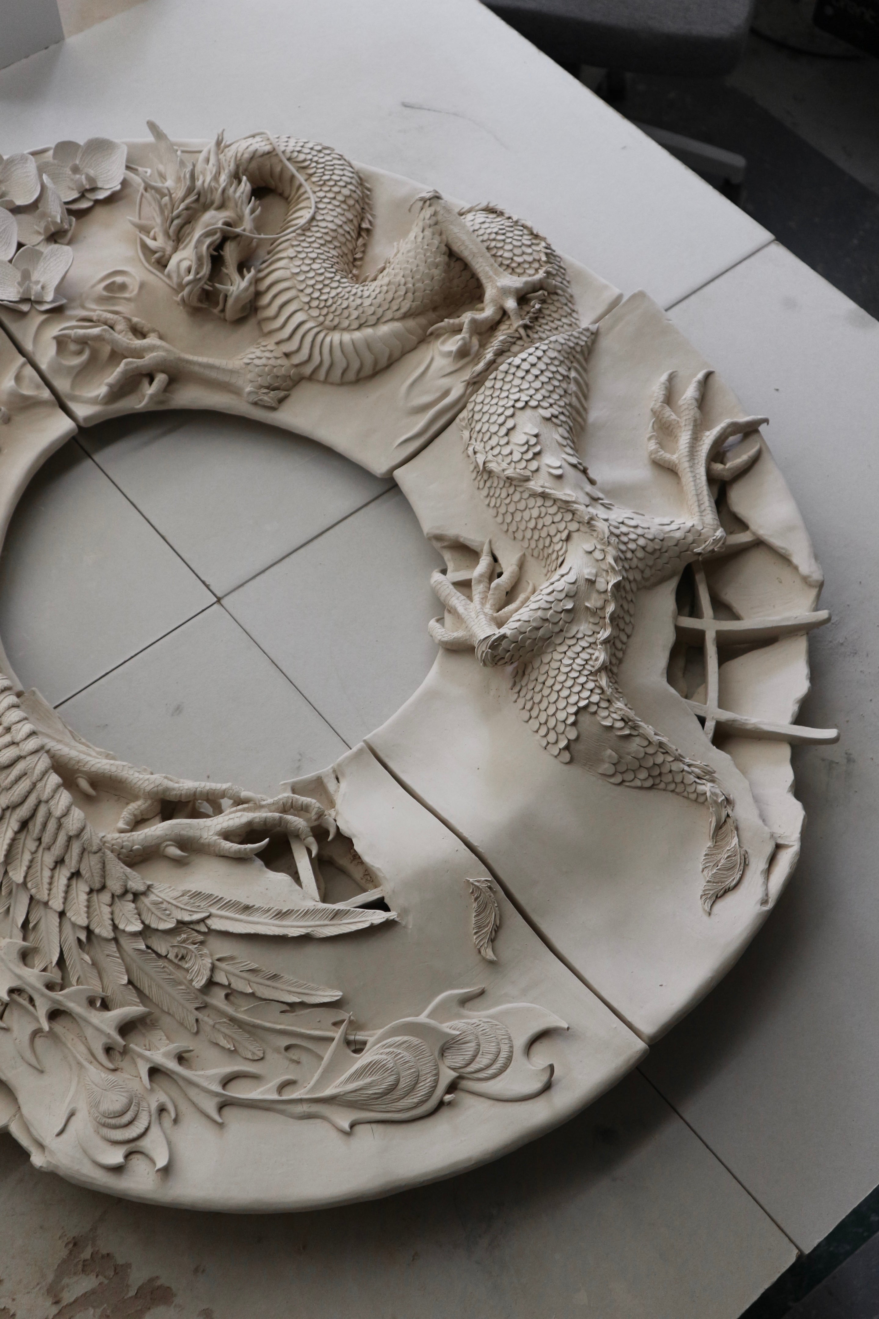 Large ceramic mirror frame with a detailed dragon, phoenix and orchid sculptures on the surface. 