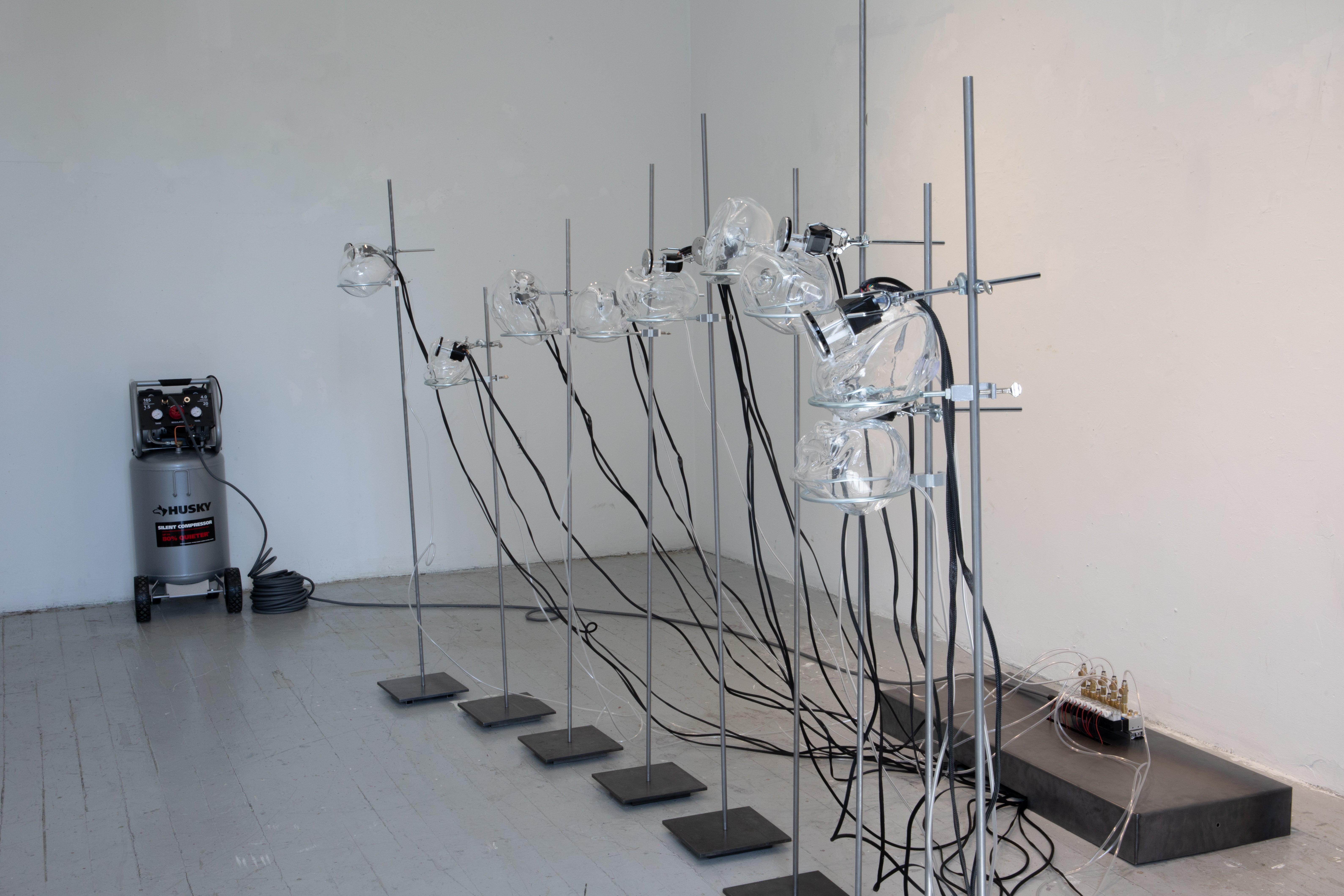 Side shot of sculpture with air compressor in background.