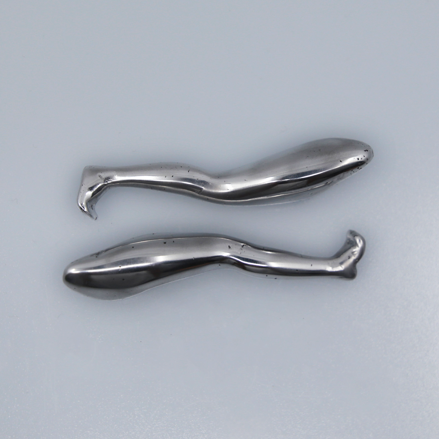 Two aluminum sculptures cast in the shape of a leg.