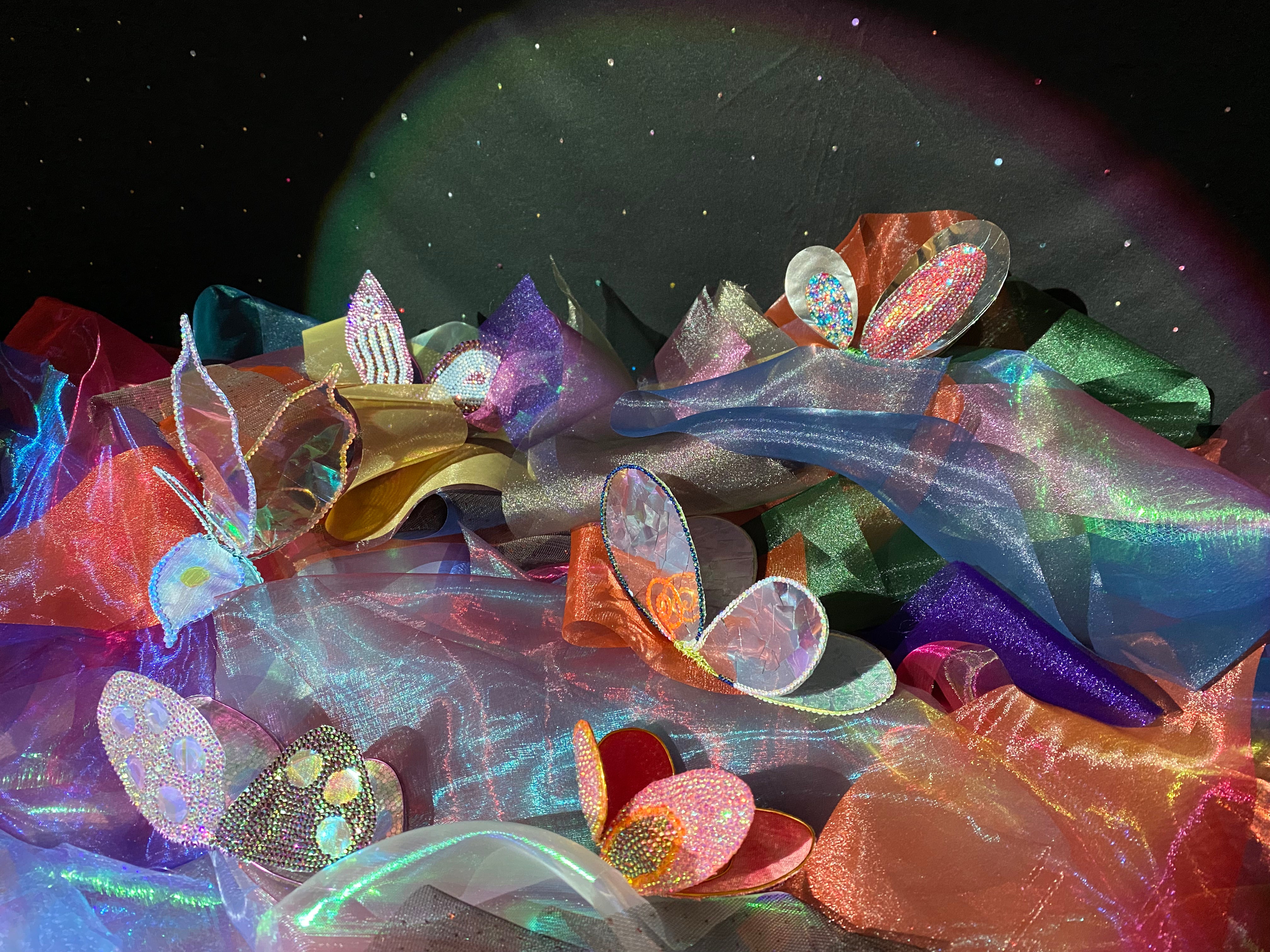 Handcrafted butterflies amongst a mixture of organza fabric. 