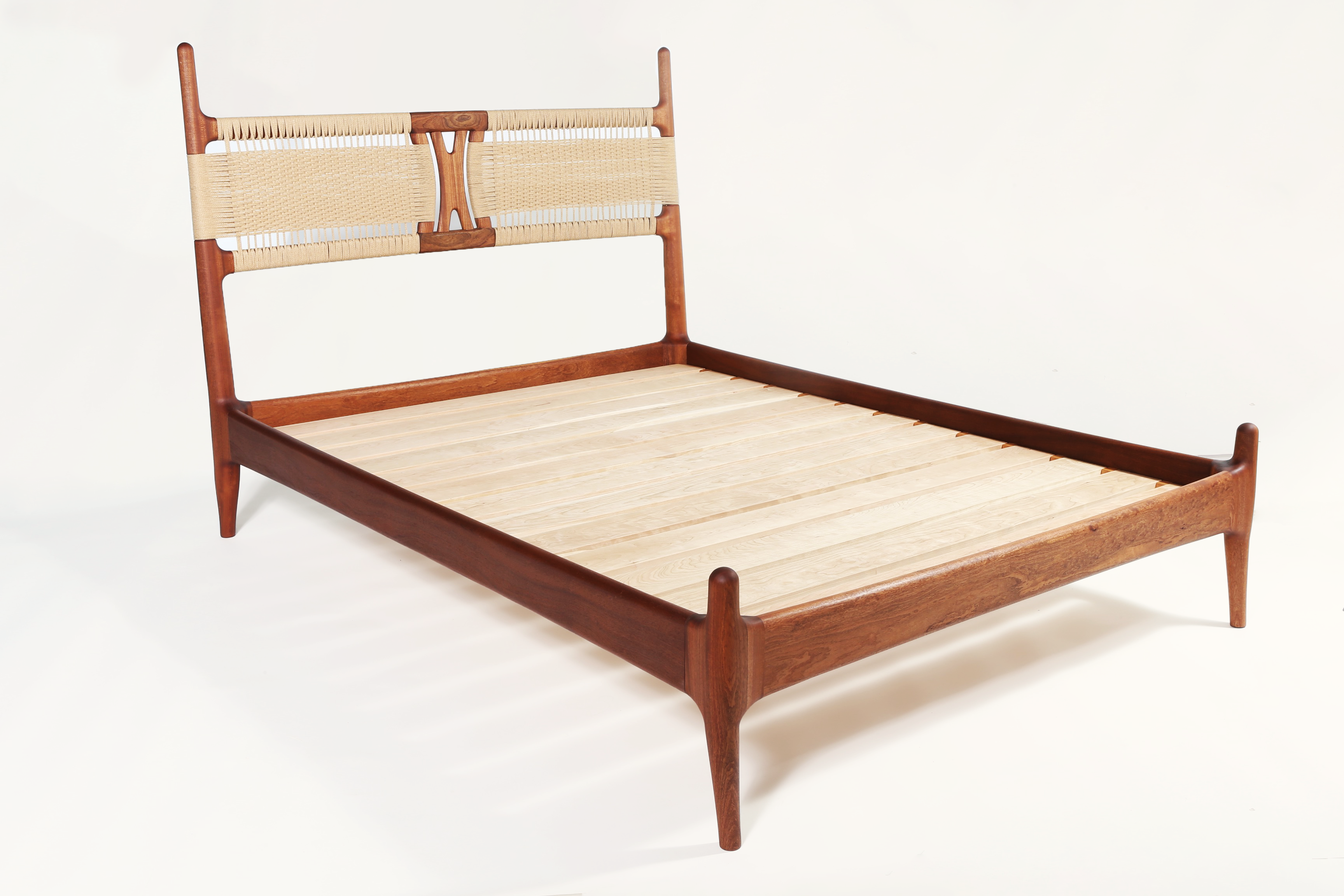 Sapele wood bed frame with woven papercord headboard on white background