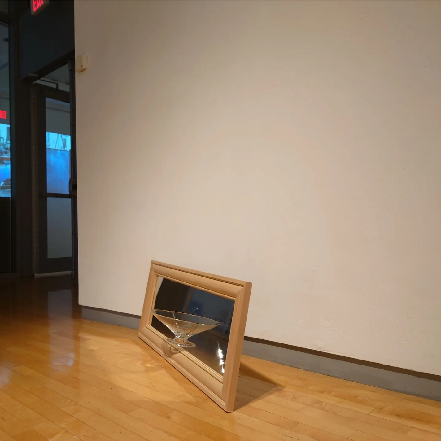 Front side of a mirror with a halved hand-blown footed dish glued on.