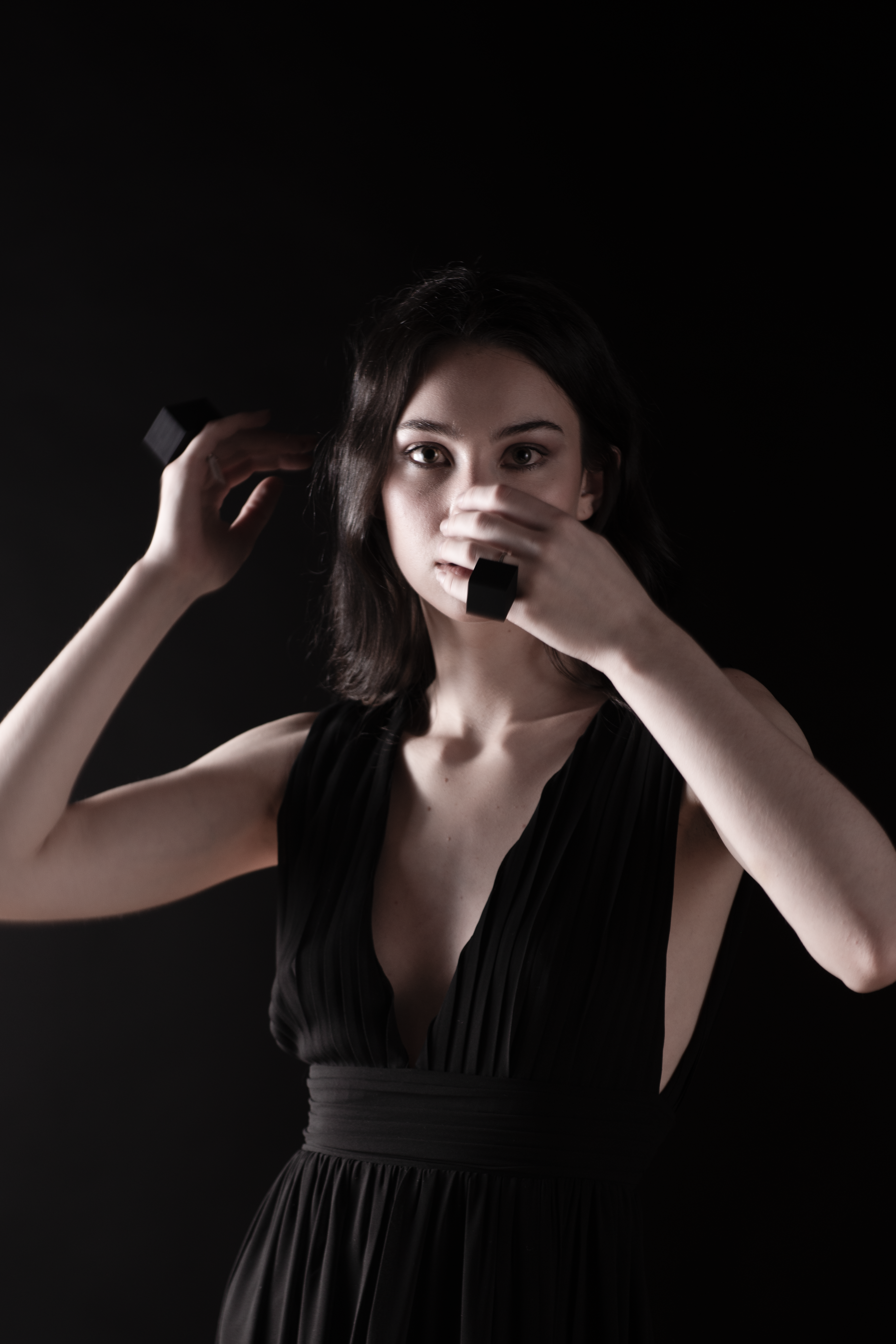 Model is wearing two rings and covering her face with her hands.