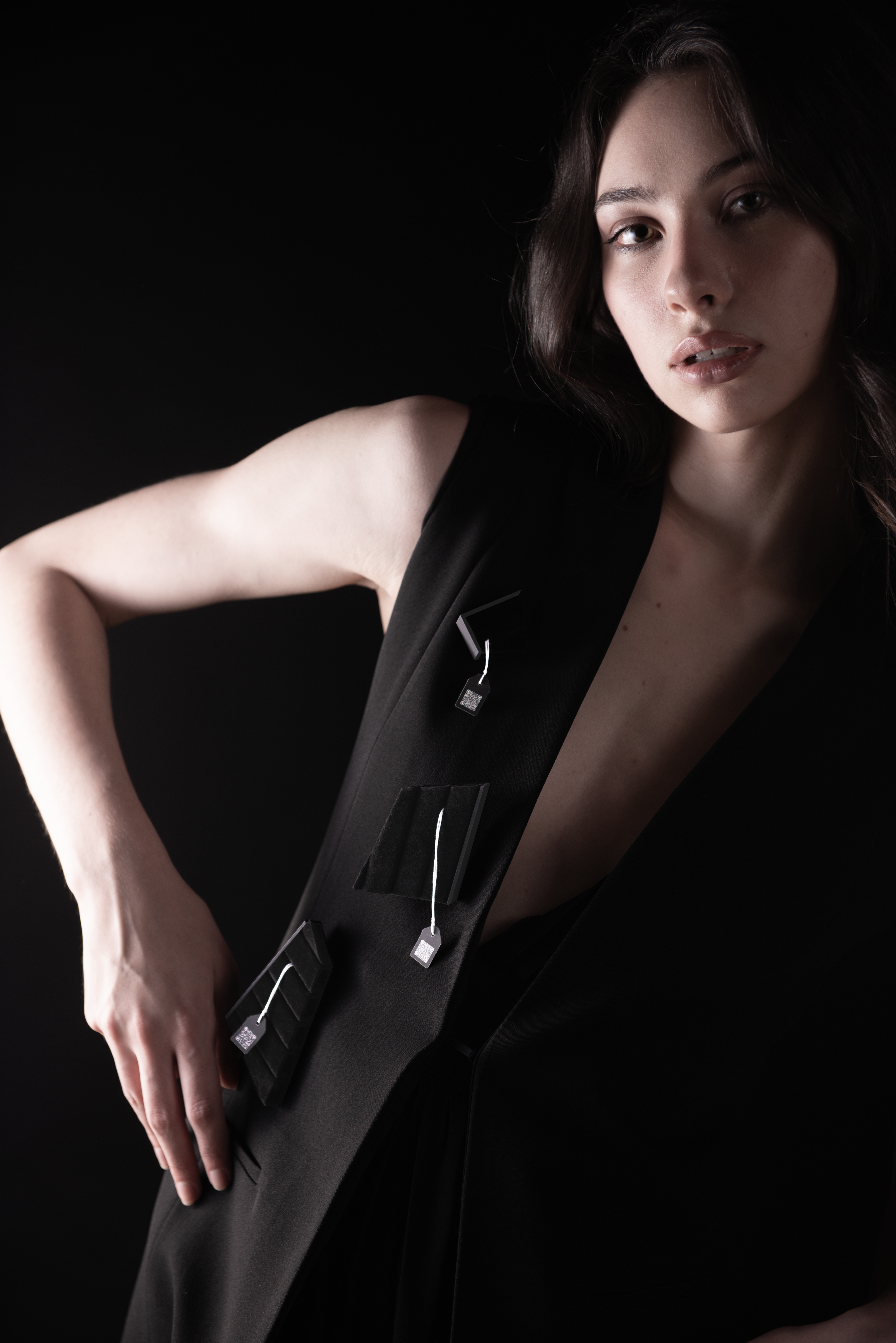 A model wearing 3 of 12 brooches on her and stand in an angle gesture.