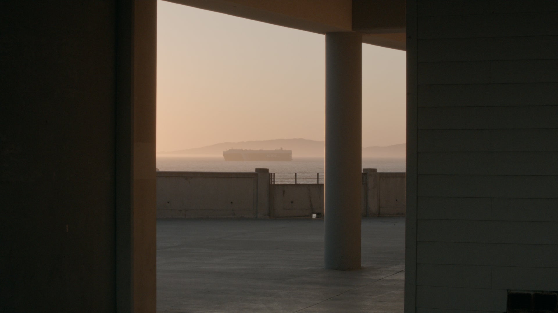 A cargo ship appears on the distant horizon