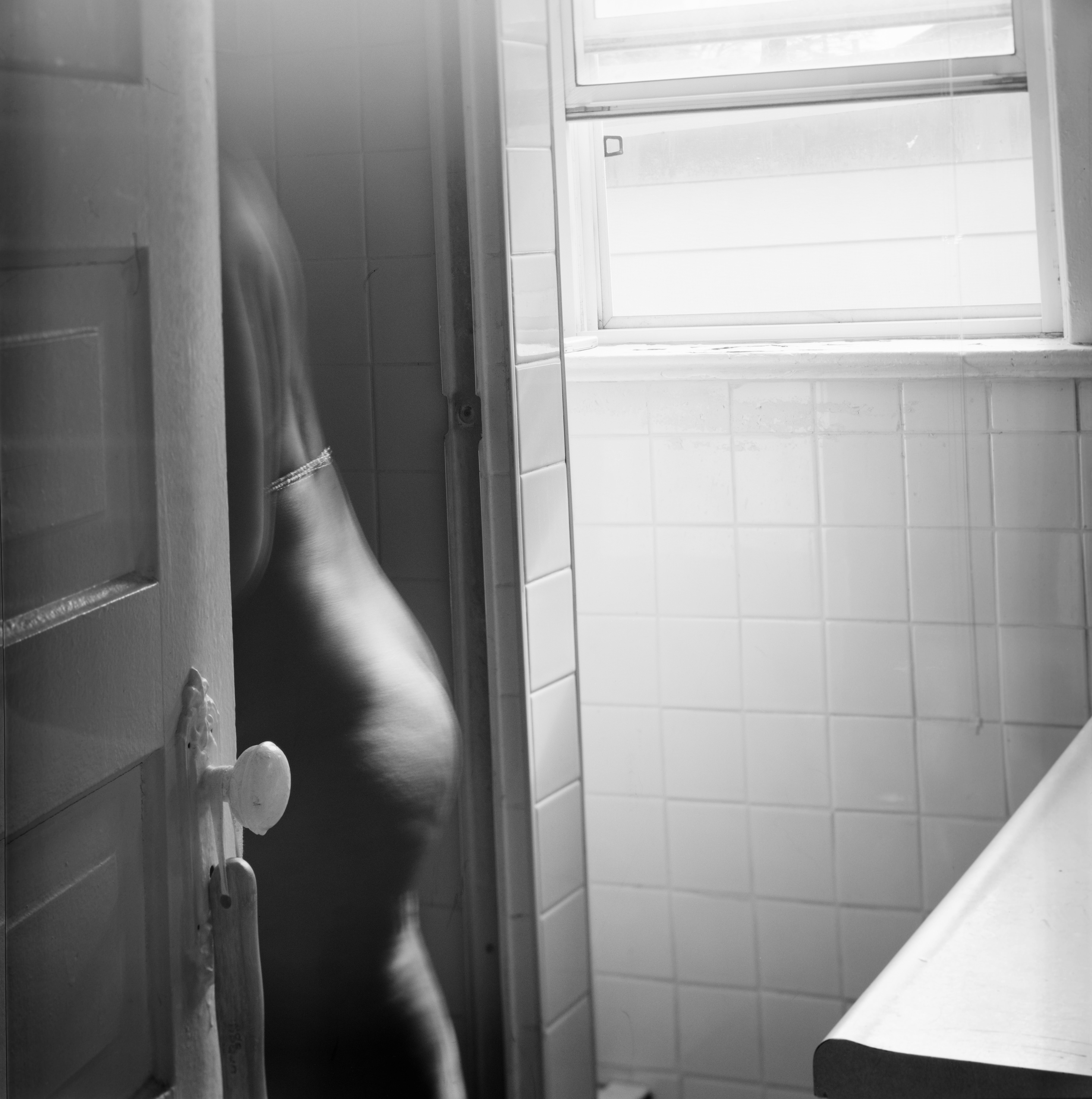a shadowed figure crosses a threshold 