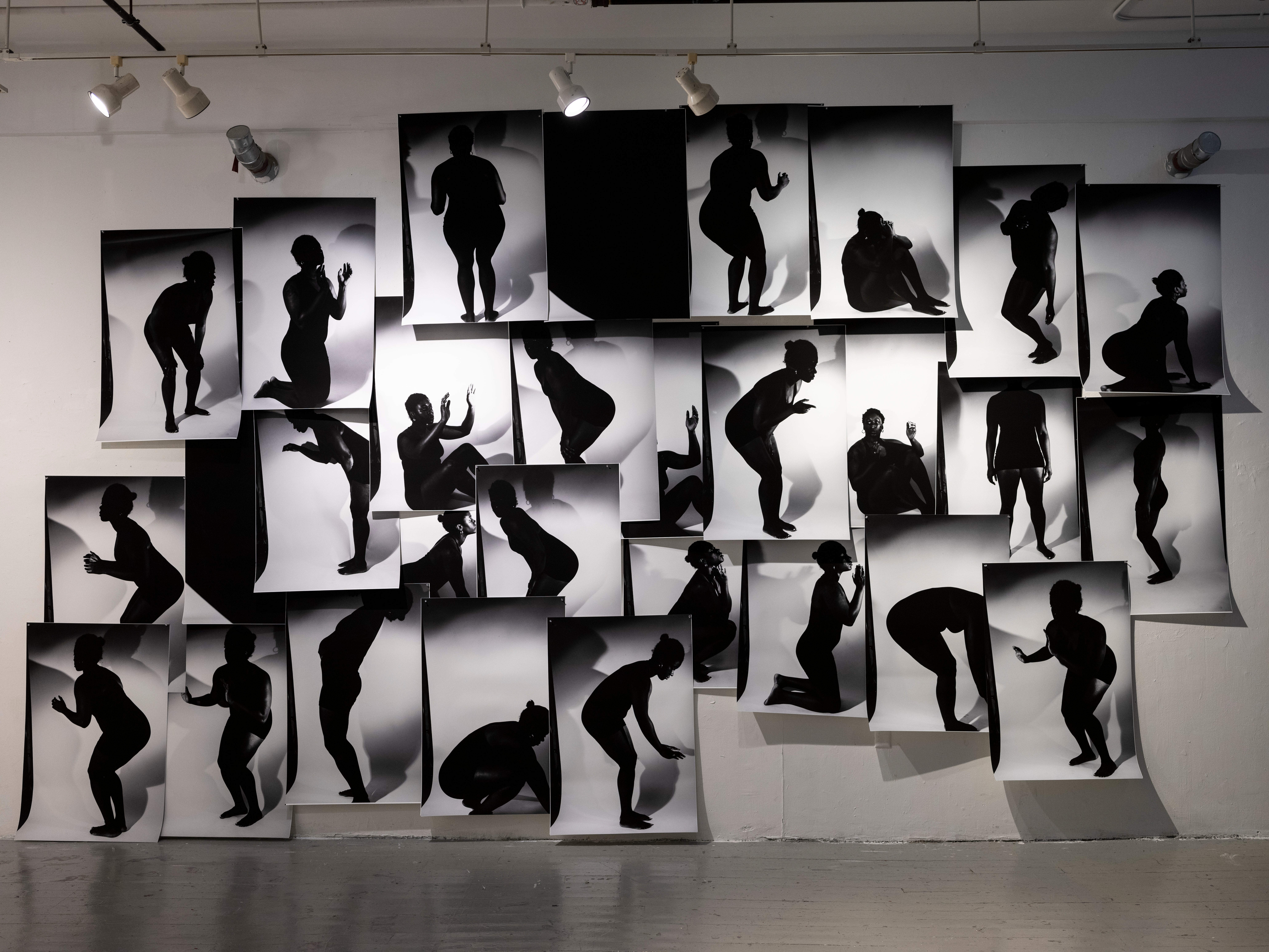 a massive collage on a wall with black and white silhouette images